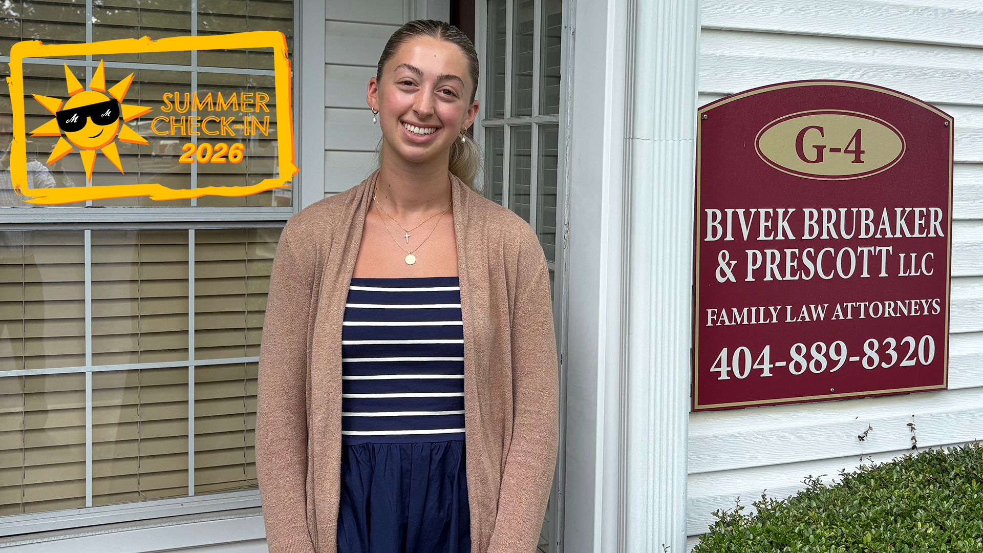 a woman in a blue dress and beige sweater standing in front of a house, next to a sign for law offices