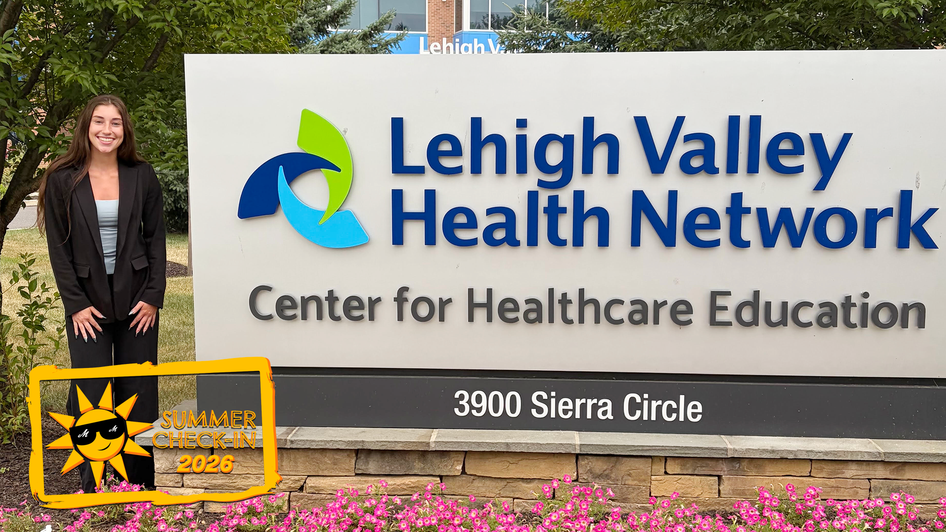 a woman in a black pants suit posing in front of a large outdoor sign reading Lehigh Valley Health Network Center for Healthcare Education