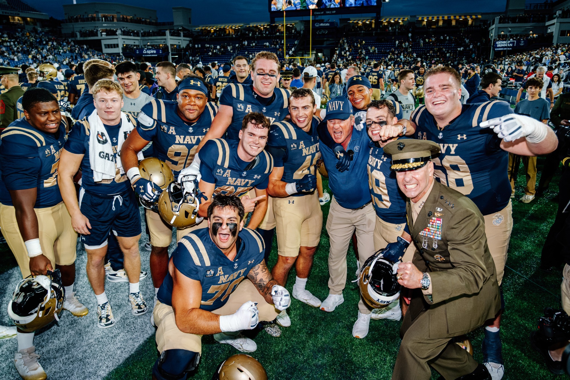 Jon Gruden celebrates with Navy players after the Mids win over Tulsa