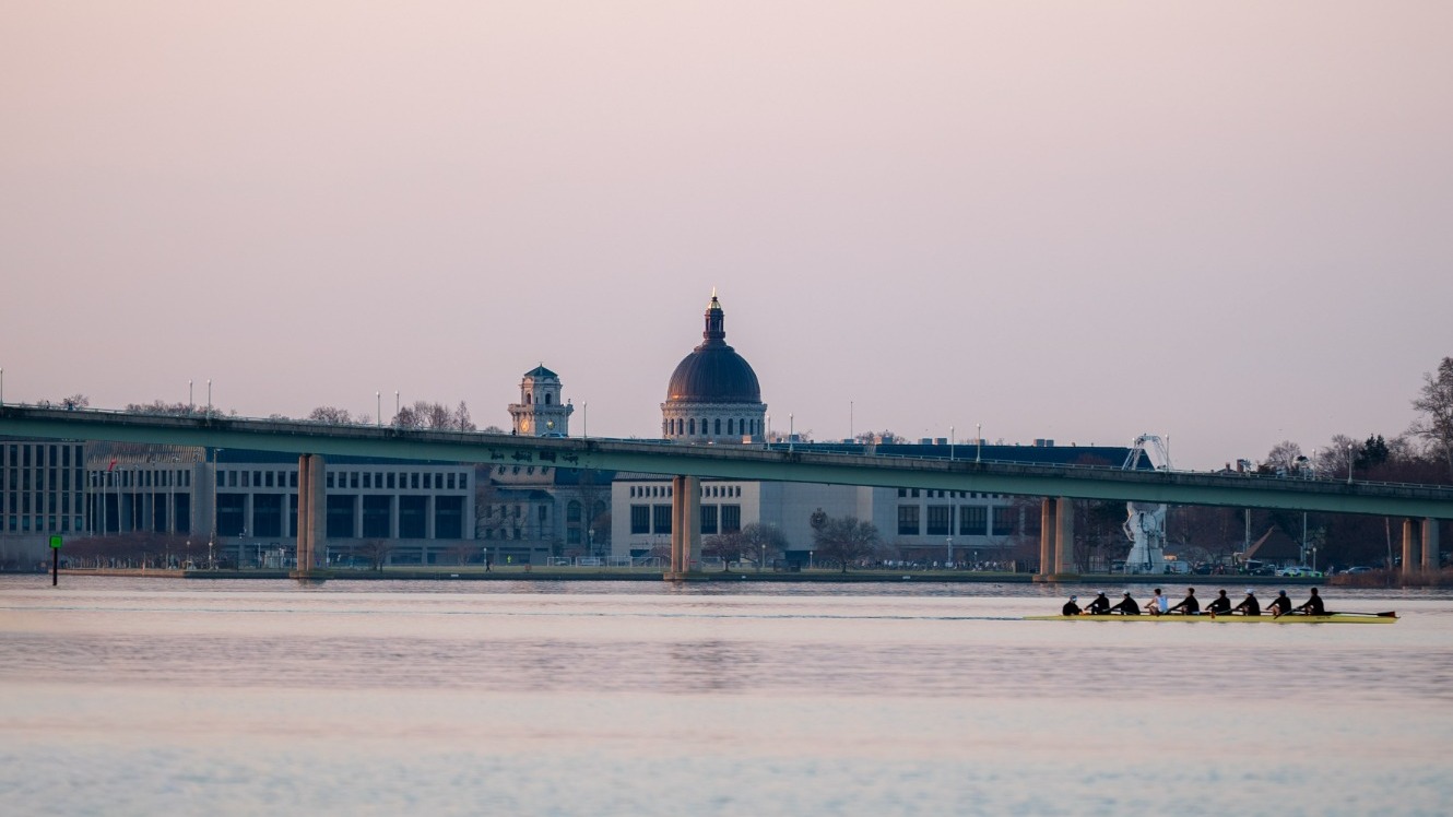 Crew with USNA in background