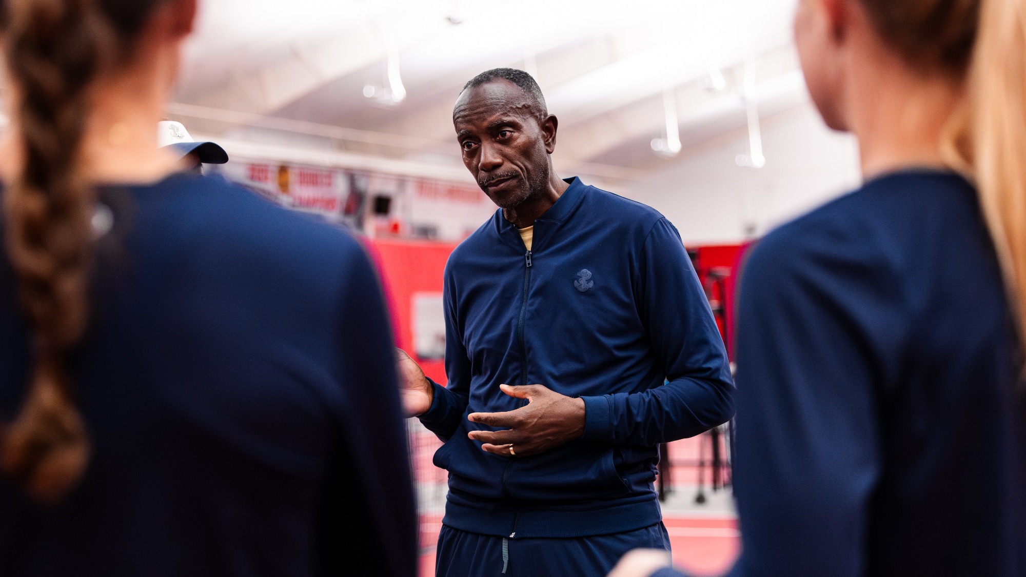 Navy women's tennis head coach Keith Puryear talks to his team following its NCAA First Round match vs. UCF on May 1, 2026 in Raleigh, N.C.