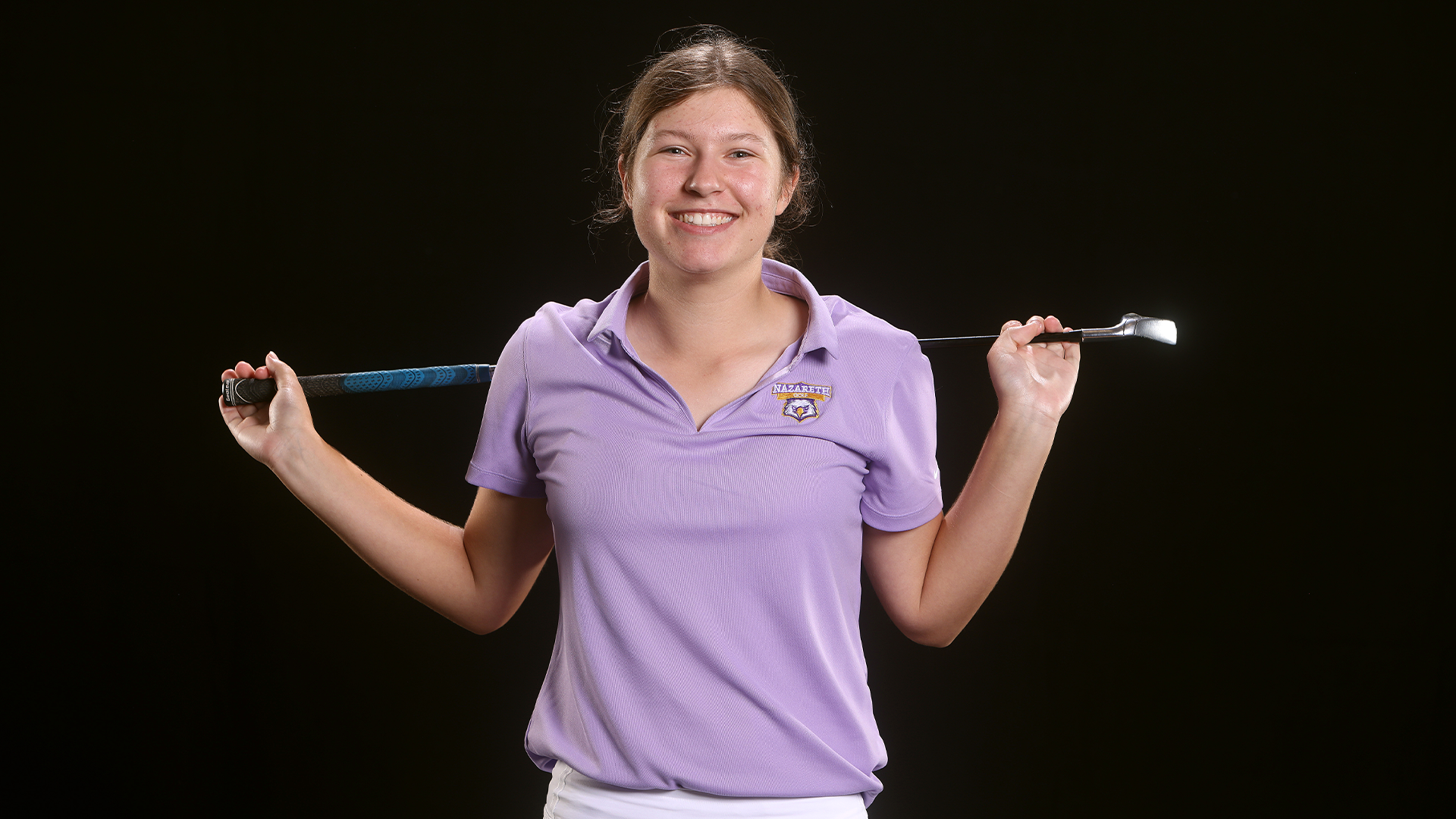 Emily Mayer with golf club over shoulders