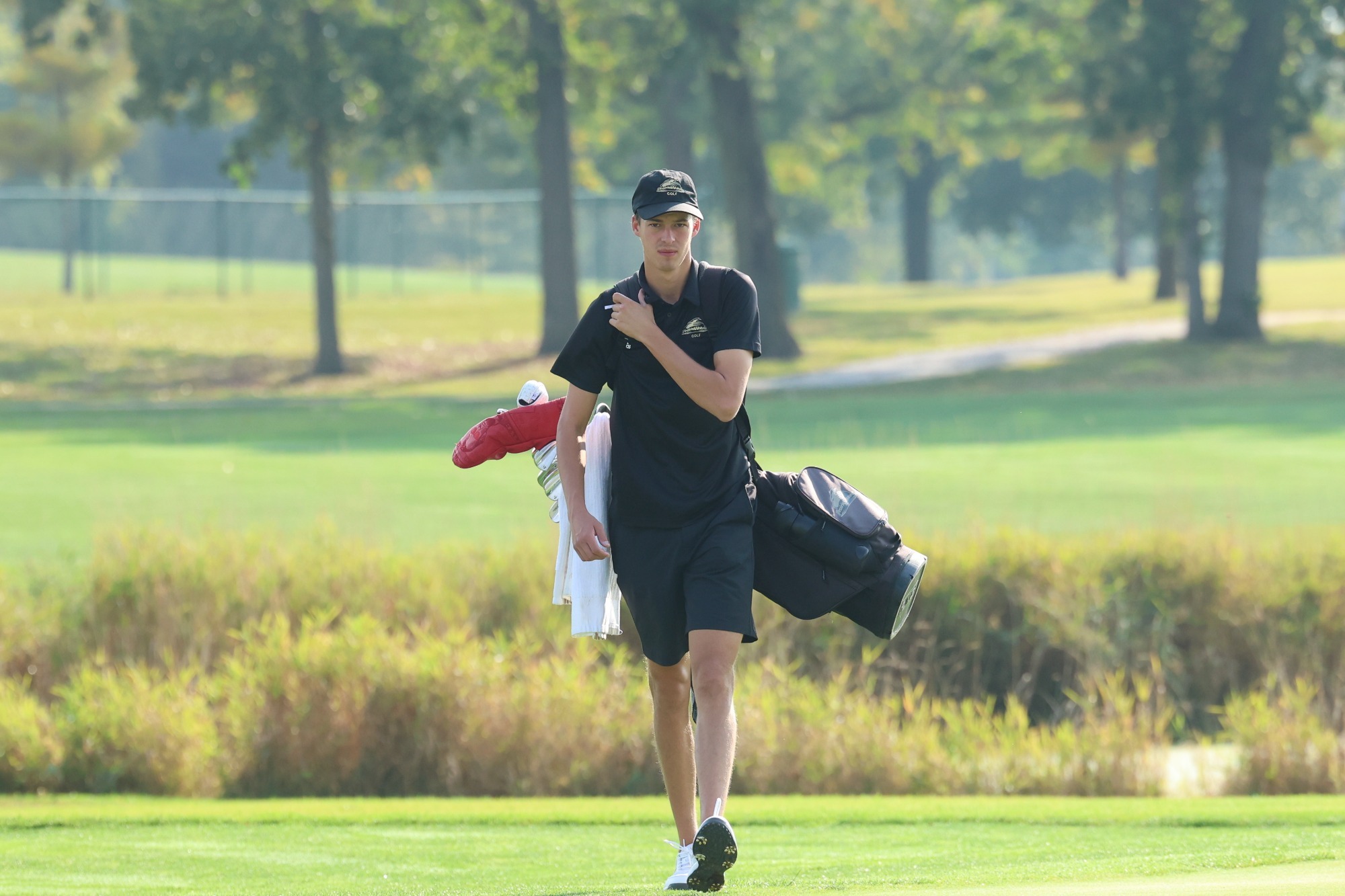 Brayden Schram carries his clubs at the Midwest Region Classic