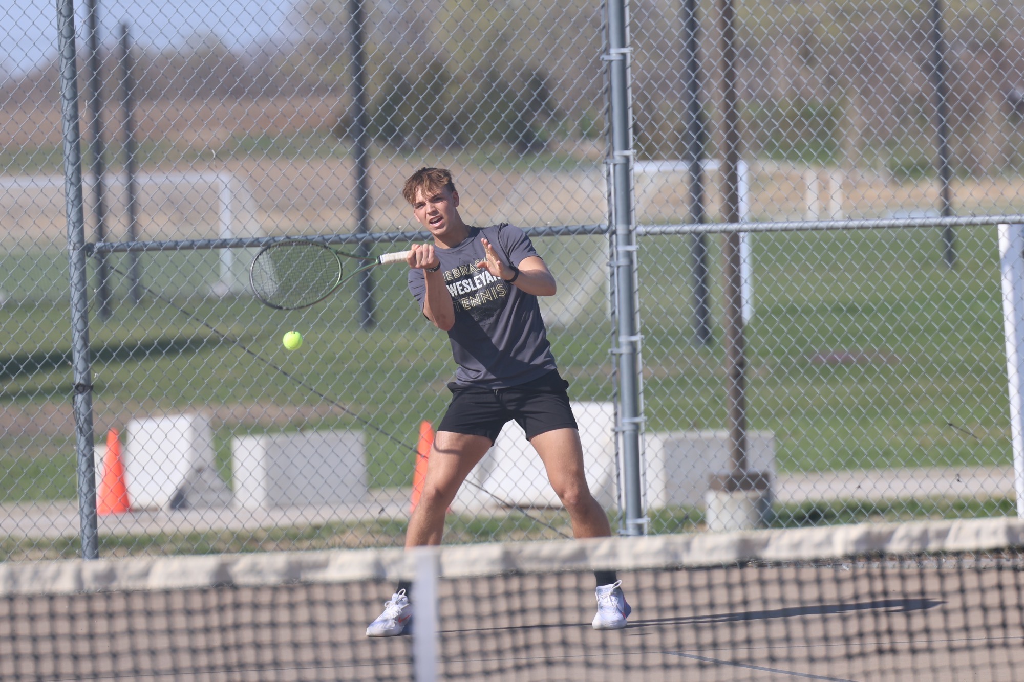 Gavin Nichols slices a forehand across the net.