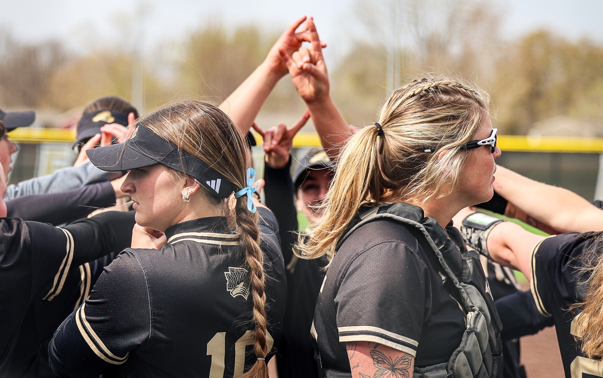 SOFTBALL TEAM huddle putting up hands