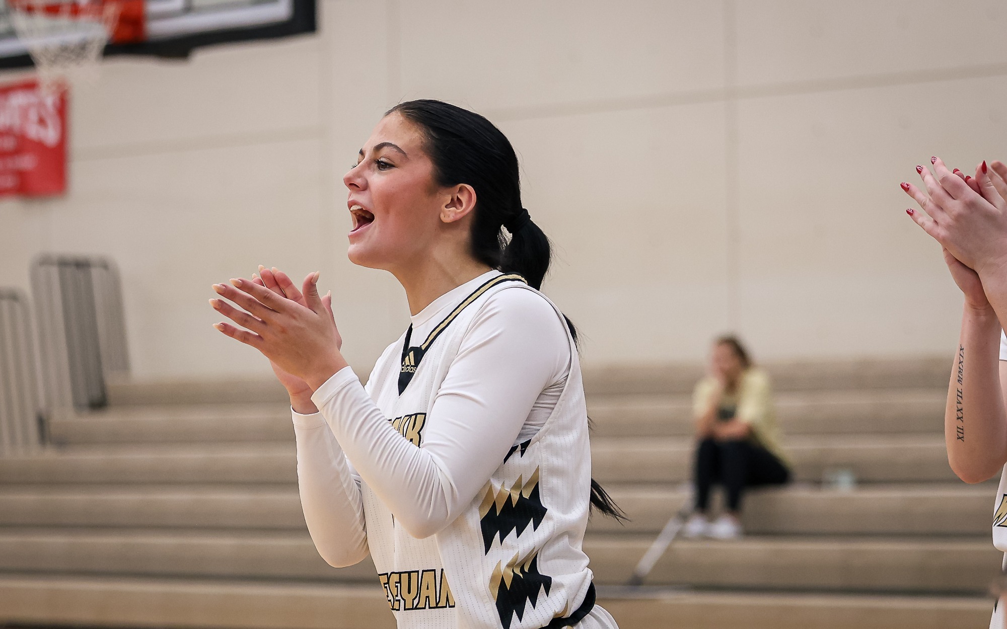 Maddie Demke applauds her teammates from the bench