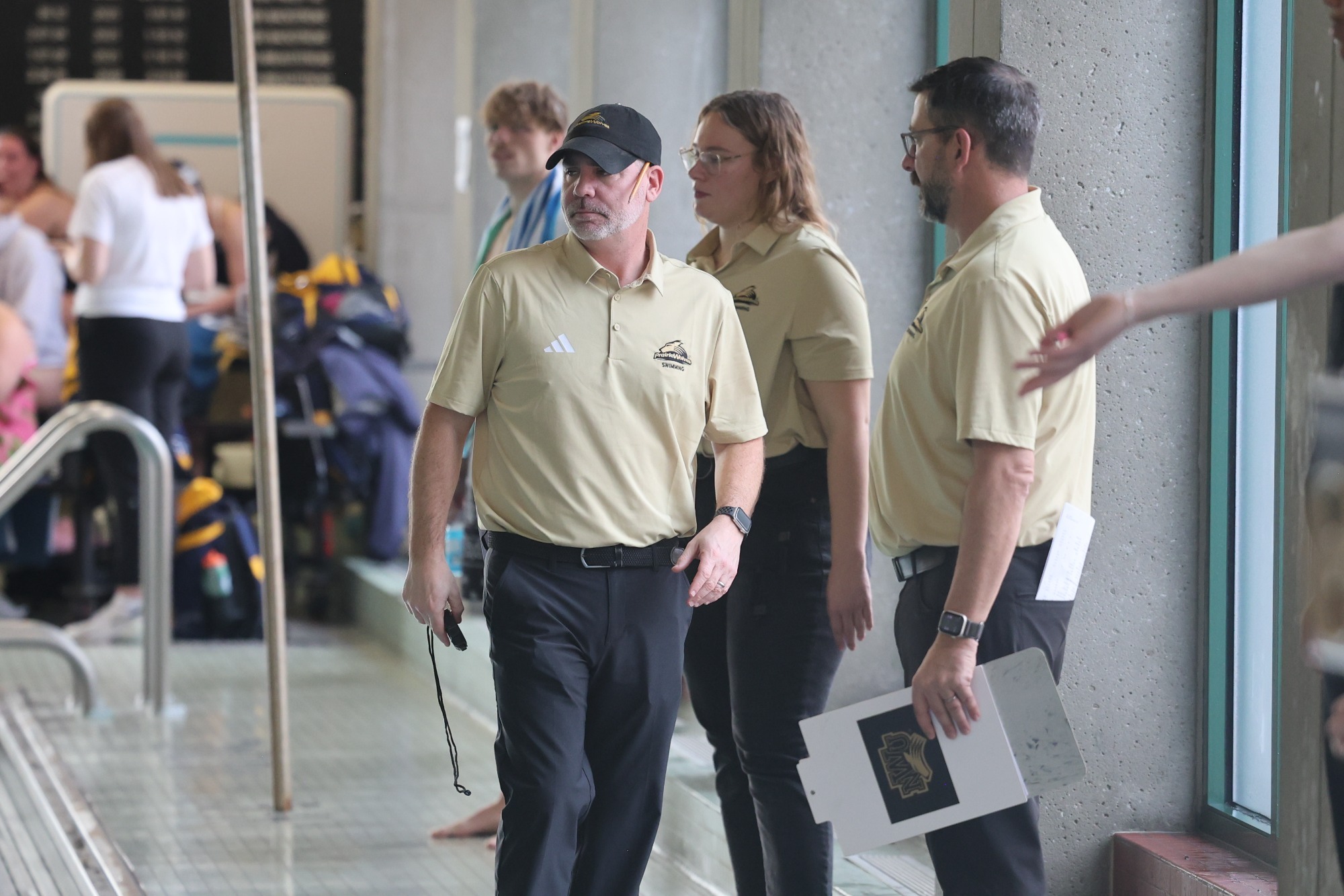 Coach Kyle Hunt looks on at a home swim meet