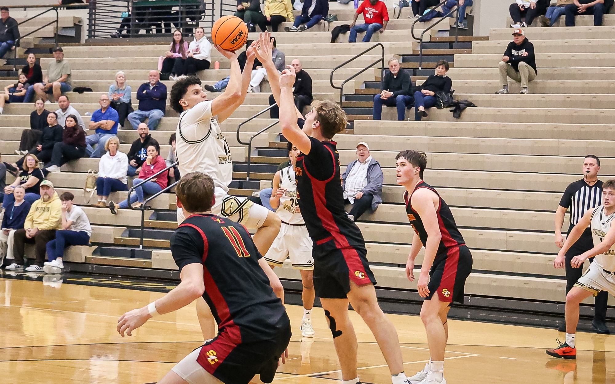 Christian Winn shoots a turn around jumper over the arm of a Simpson Defender