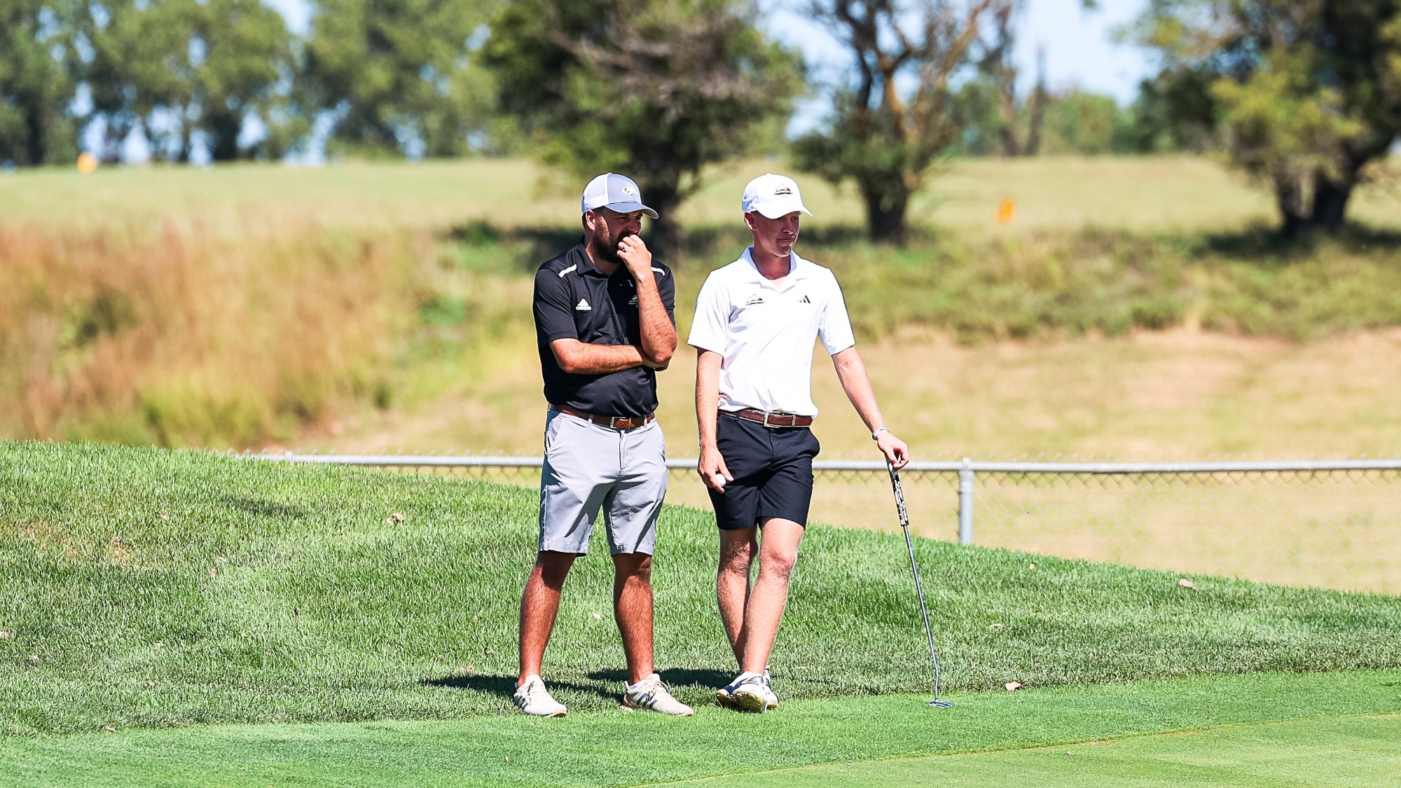 Coach Kontor and Harrison Weddell talk about a put off to the side of the green.