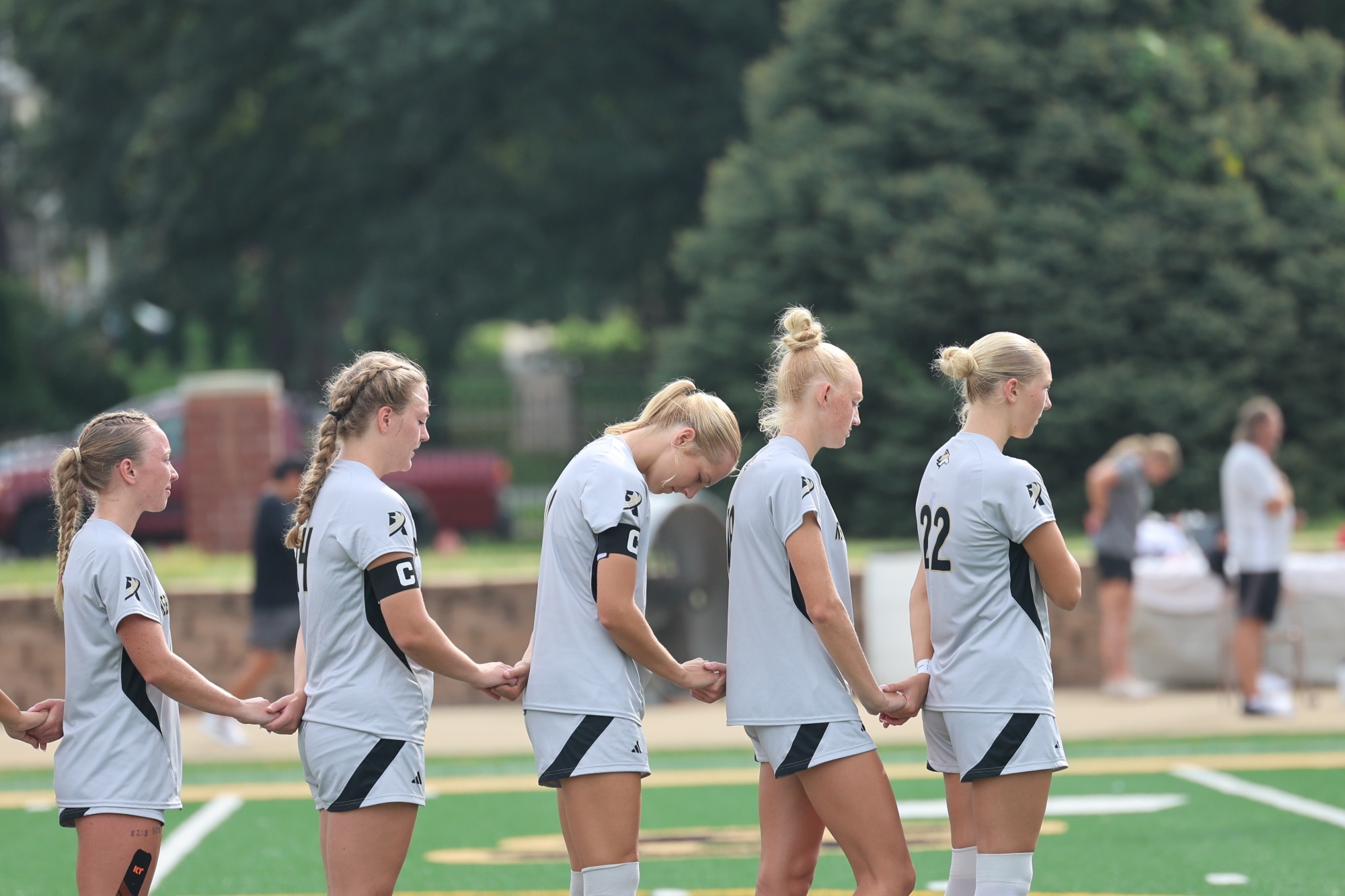 NWU Women's Soccer holds hands during the national anthem