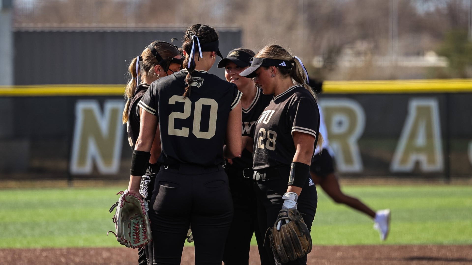 Pitcher's Huddle around Eva Fahrnbruch to hand her the ball