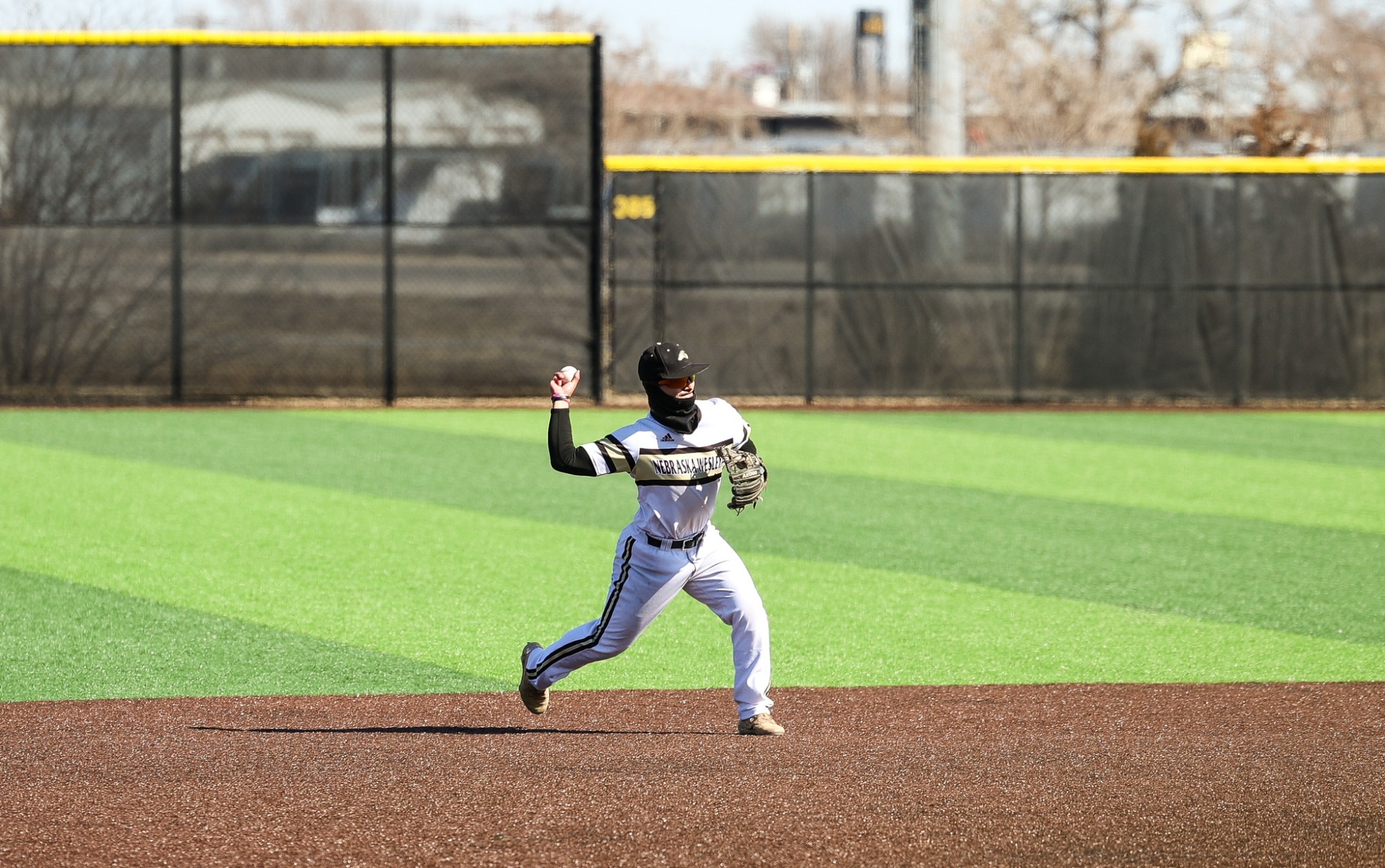 Brady Bell throws a ball against Grinnell