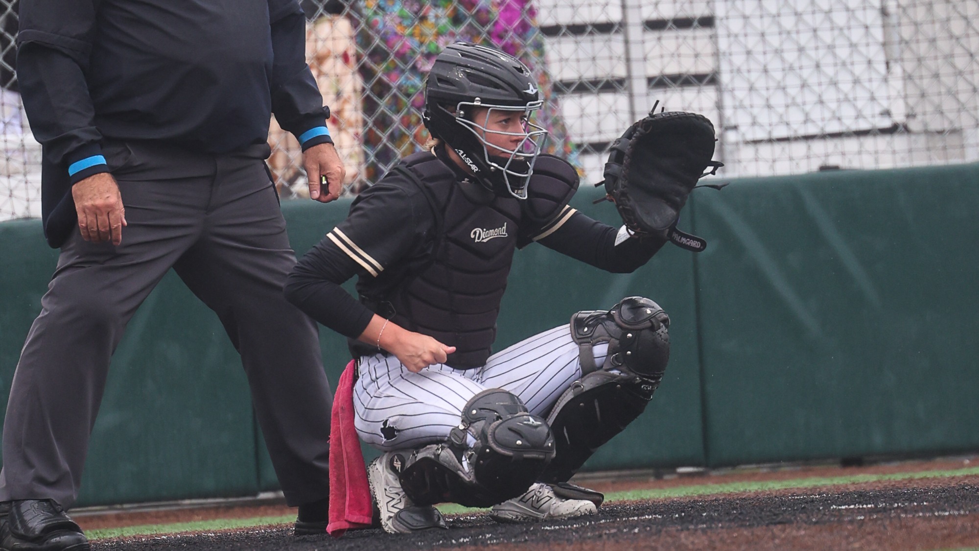 Moe Colegrove sits in the catcher position on a wet day