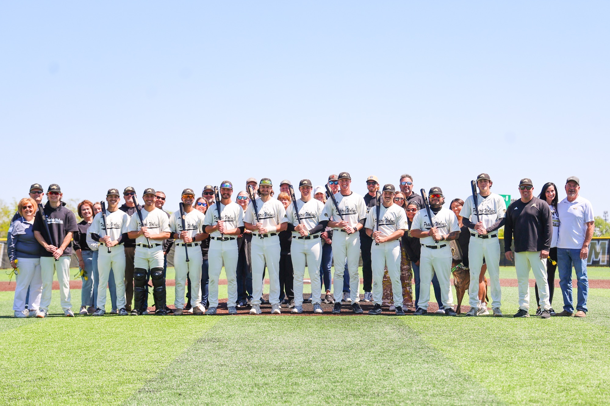 2026 Seniors pose with their parents at the pitchers mound