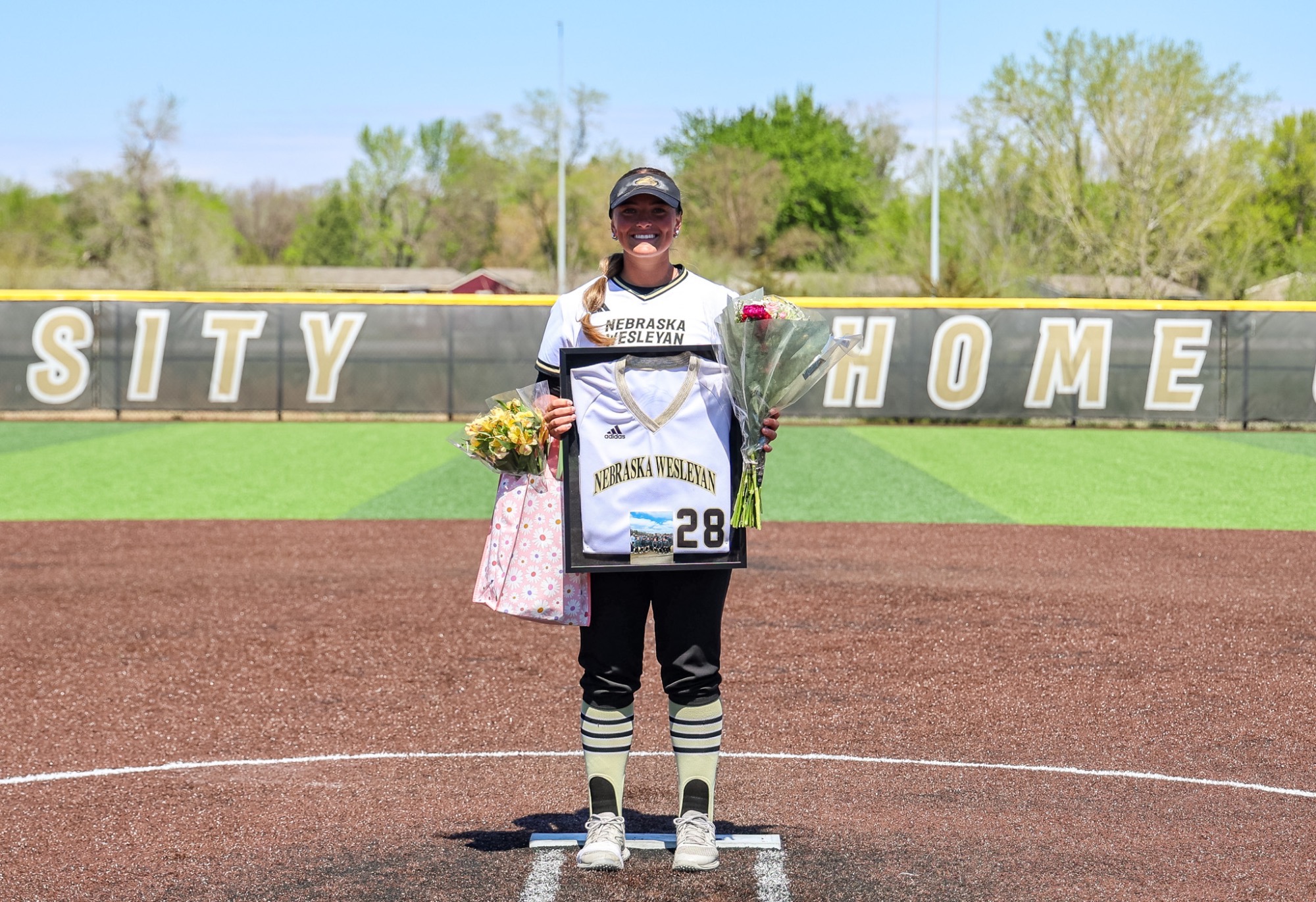 Jenna Kimberling poses with her framed jersey and flowers on Senior Day