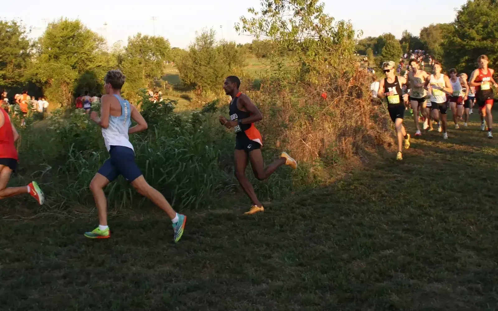 Denner Dos Santos running around the corner in front of a lot of people at the Missouri Southern Stampede Cross Country meet.