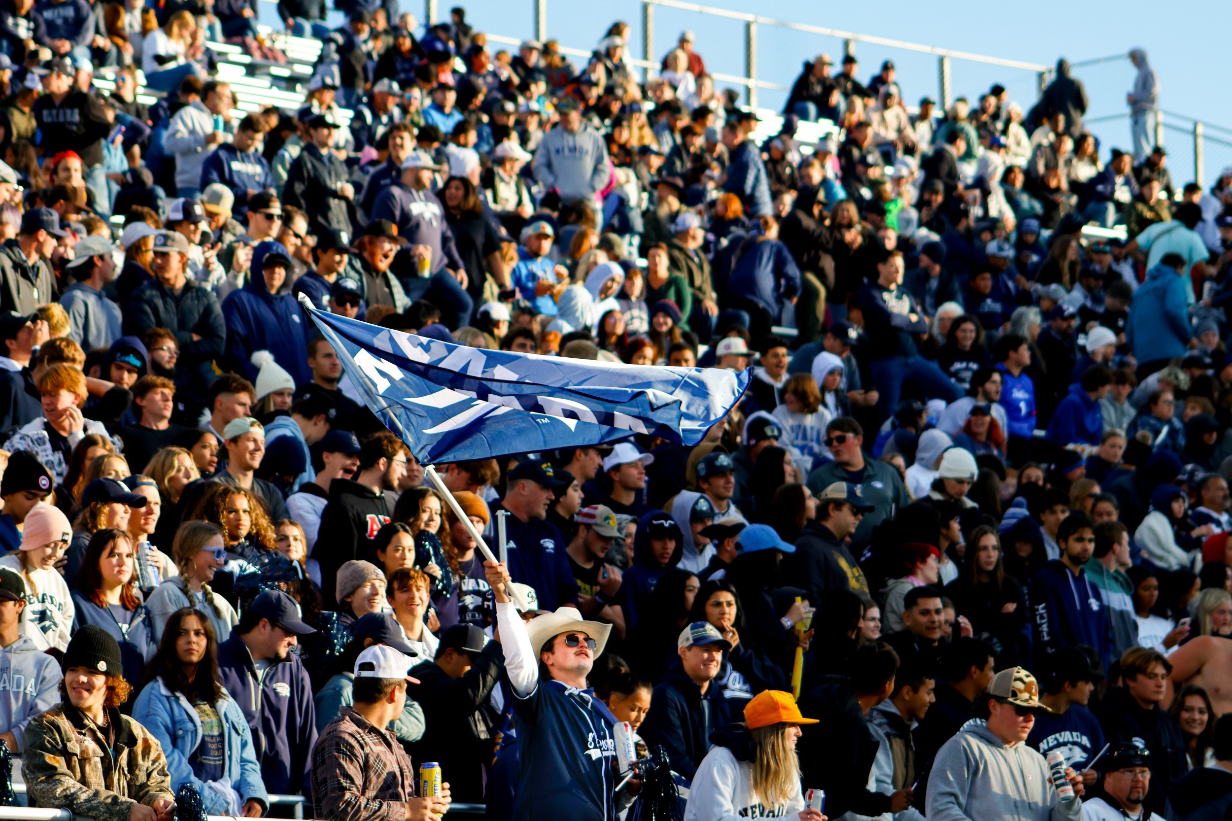A Nevada fan waves a Nevada Athletics flag in the Mackay Stadium stands