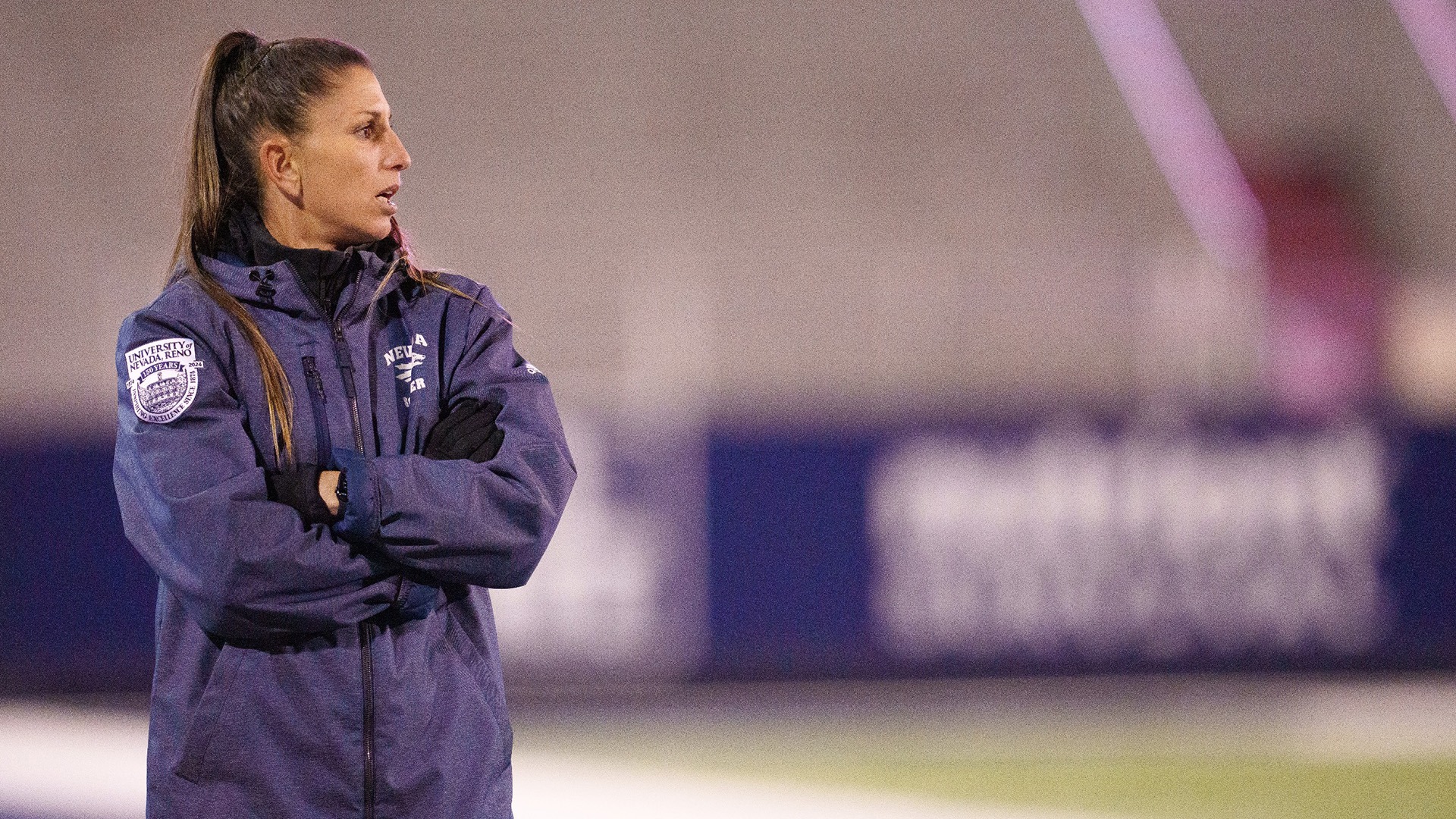 Vanesa Valentine on the sideline with her arms crossed