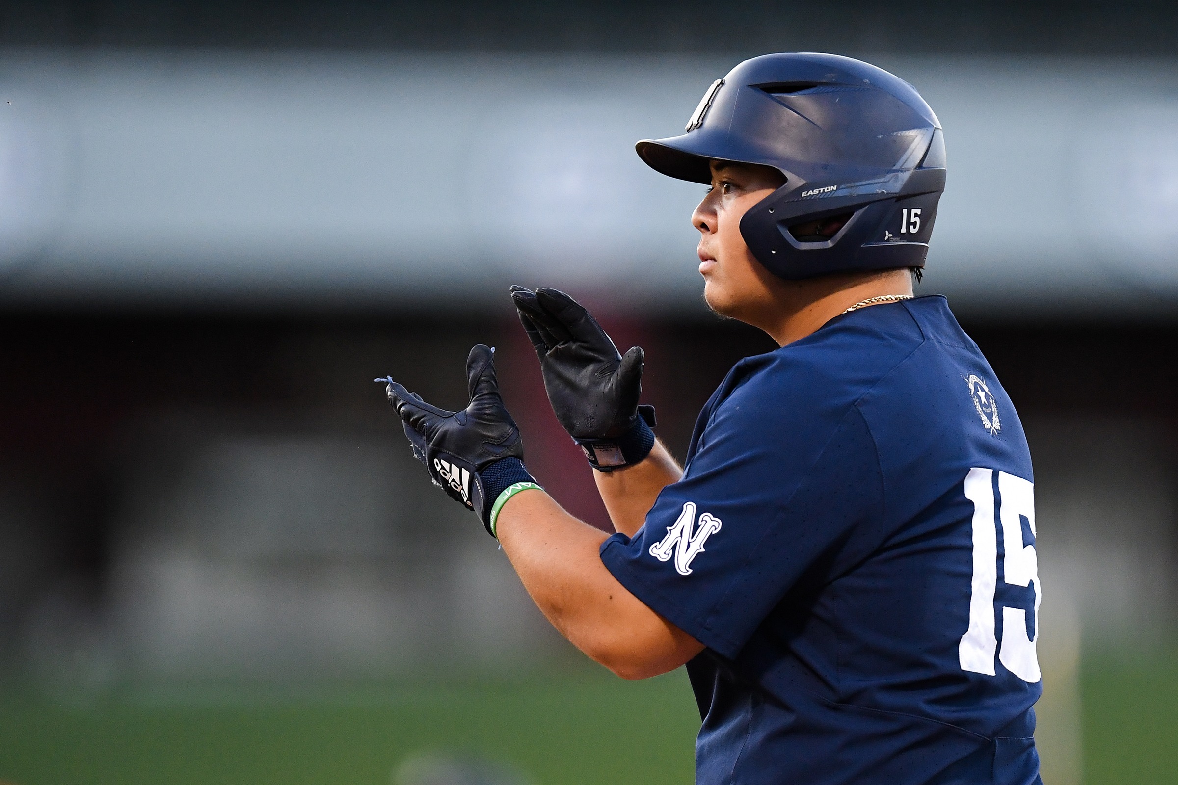 Sean Yamaguchi claps his hands while standing on first base