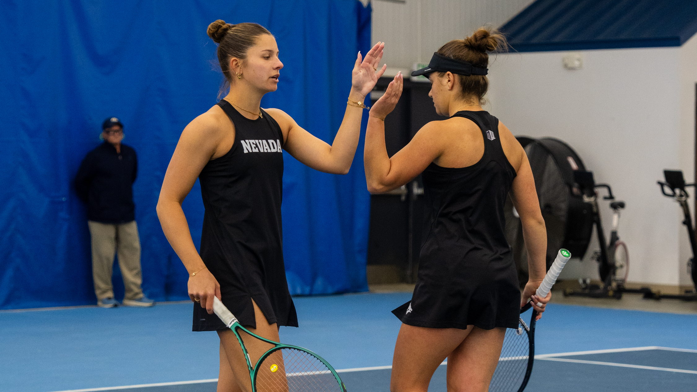 Nevada women's doubles team high fives after a point