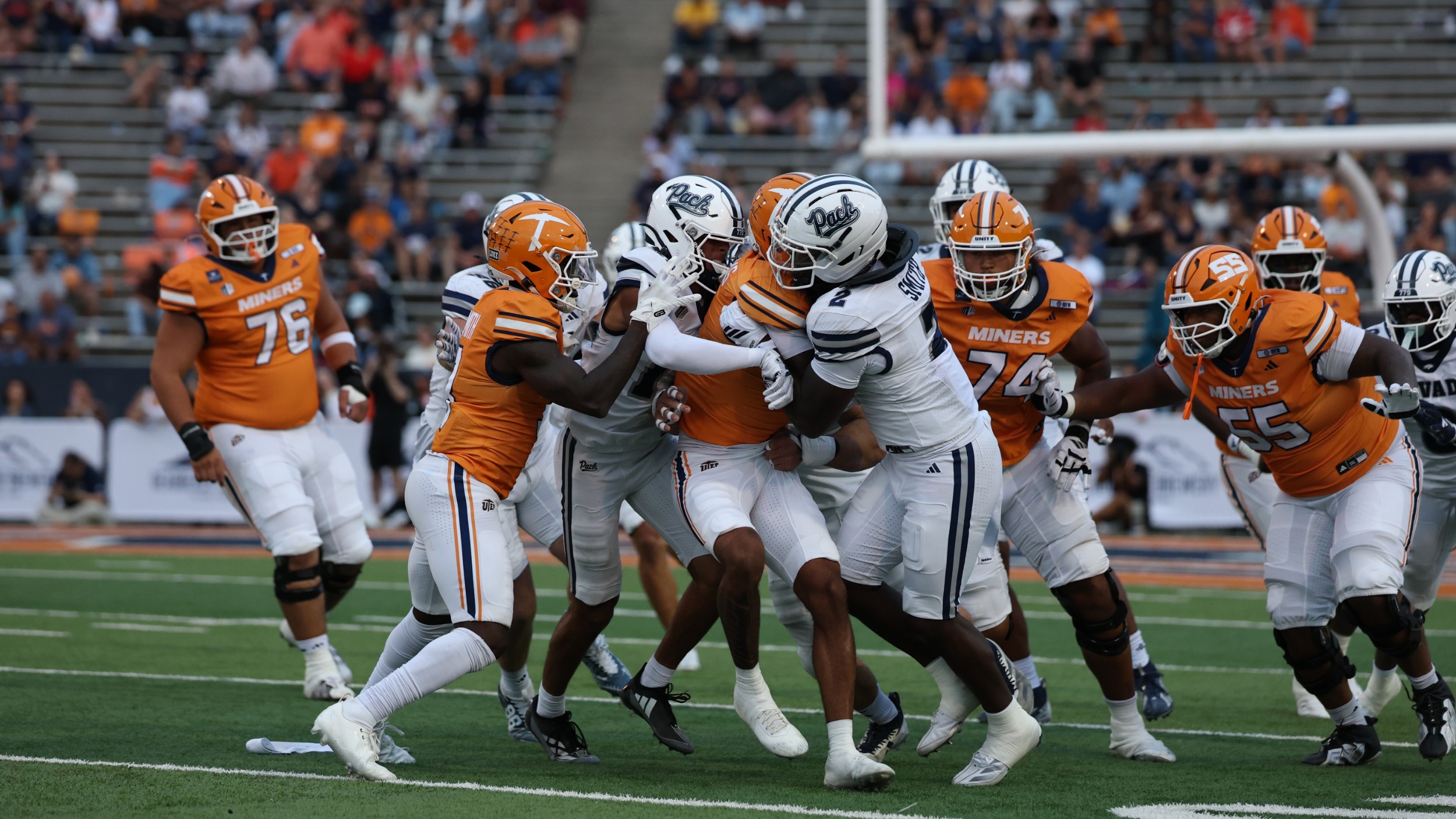 Two Nevada defenders tackle a UTEP ball carrier