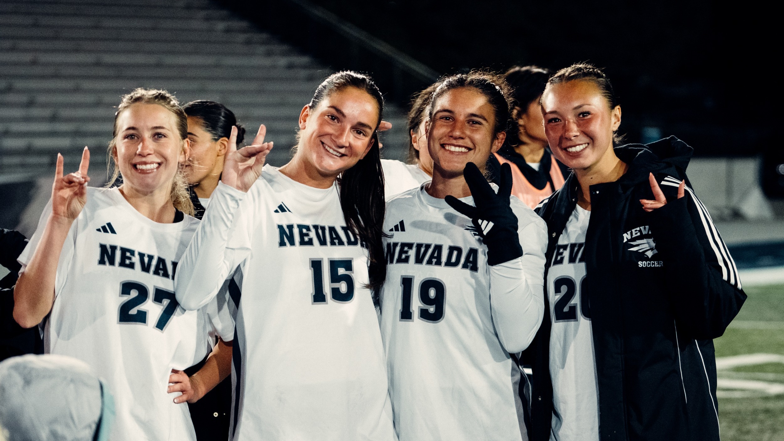 Girls celebrating the win holding up the W