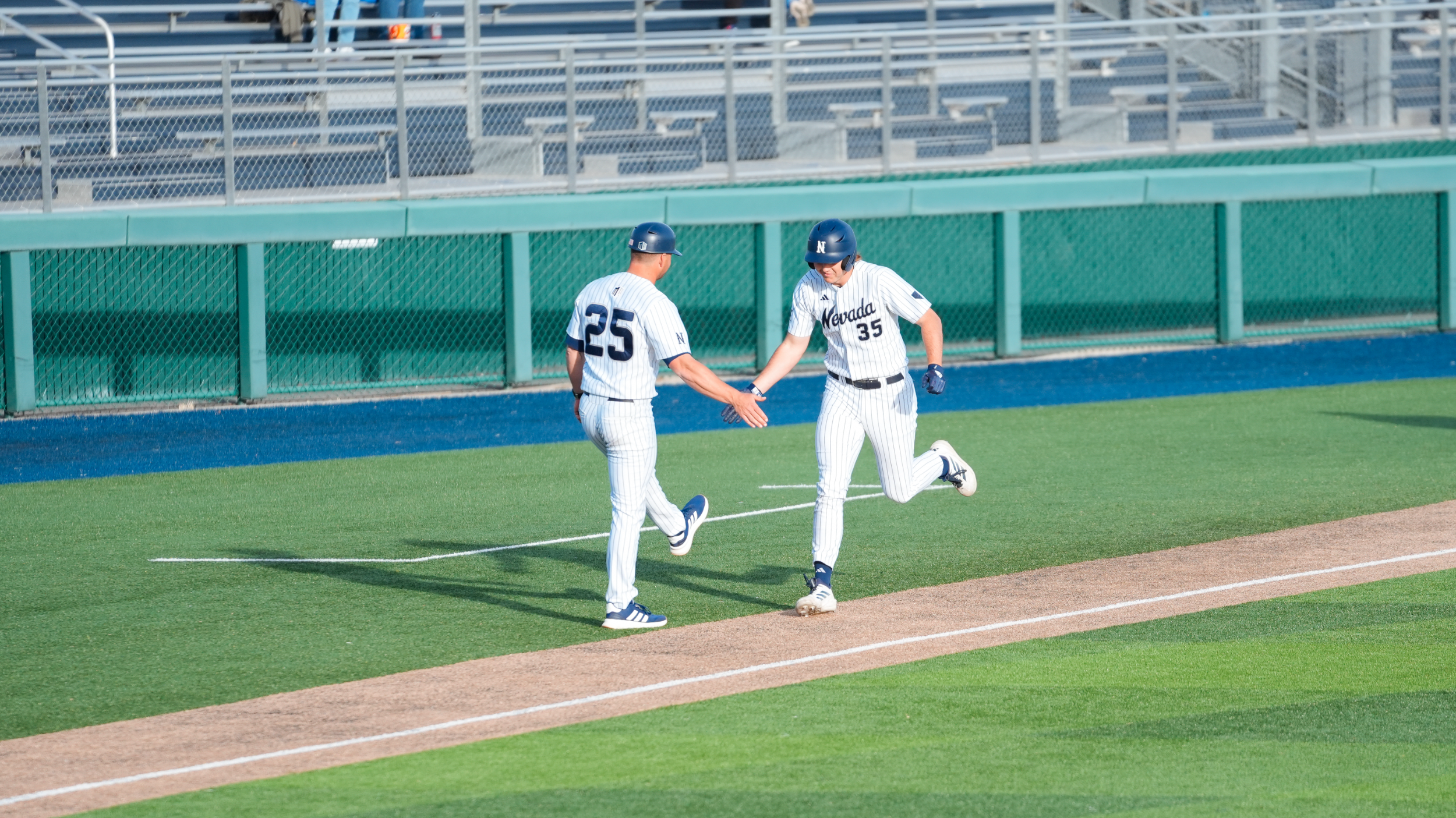 Jacob Doyle shakes Jordan Getzelman's hand rounding third base on a home run trot