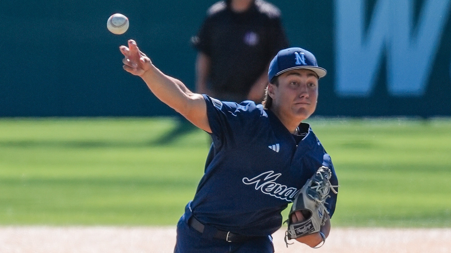 Jordan Giacomini in a navy blue uniform delivers a pitch