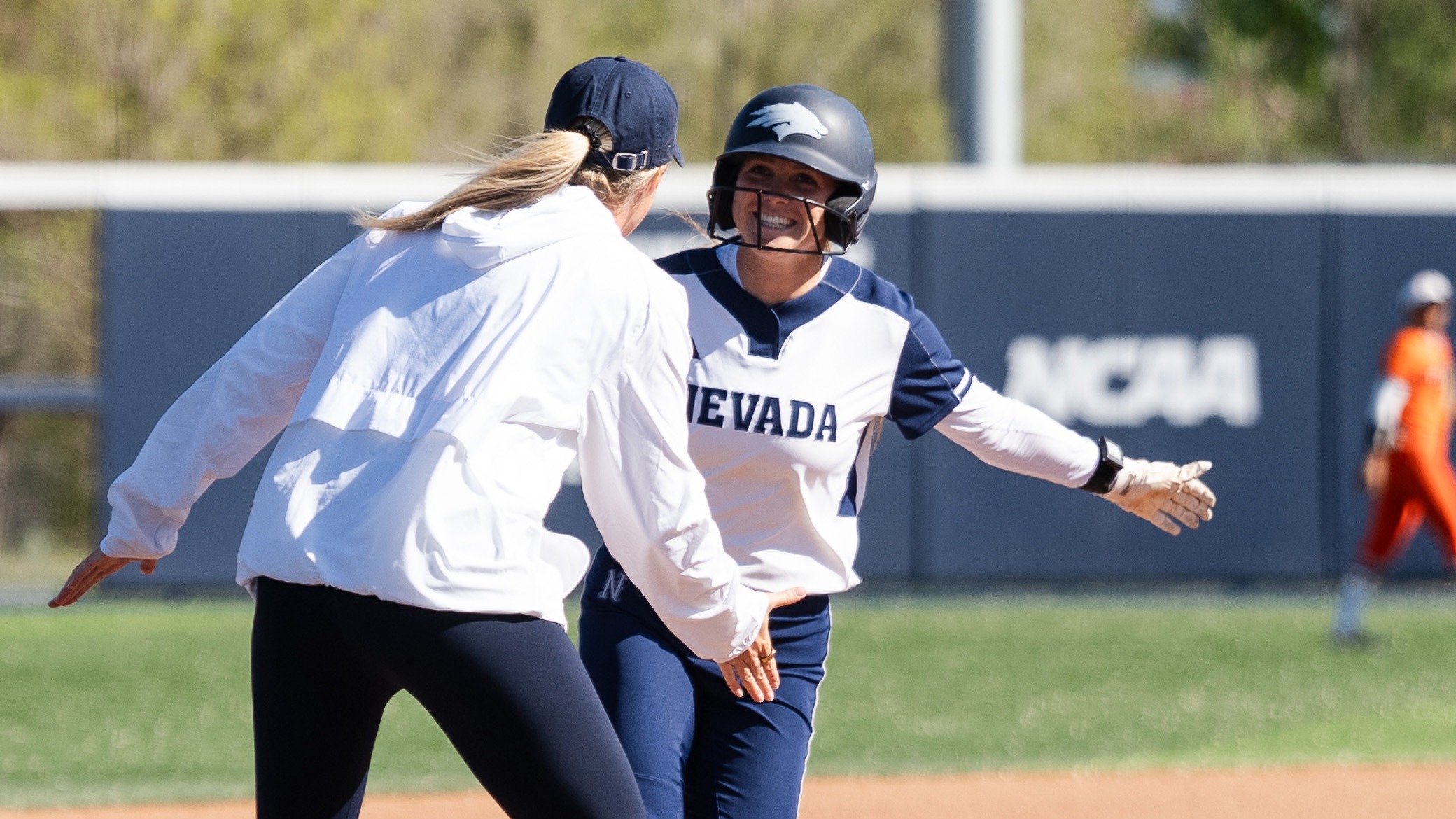 Haylee Engelbrecht shakes hands with Victoria Hayward rounding third base