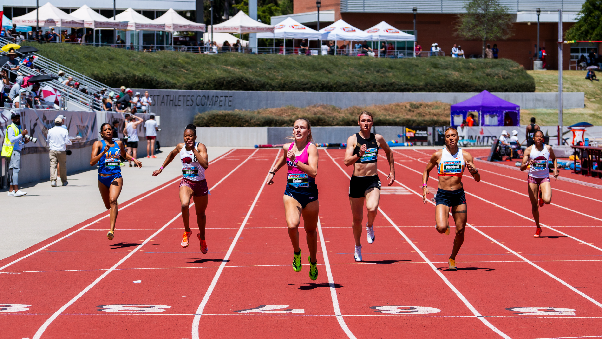 Annalies Kalma crossing the finish line of a race with two racers either side of her