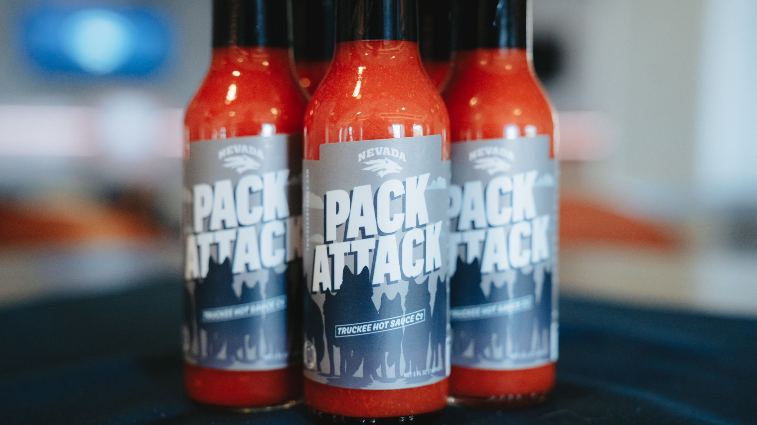 Image of three hot sauce bottles with PACK ATTACK on the labels
