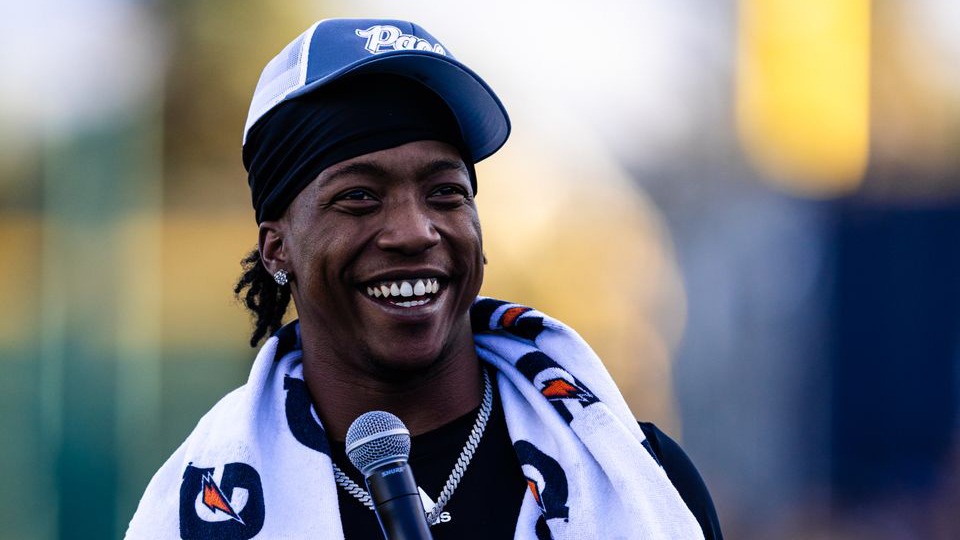 Ky Woods smiles while holding a microphone