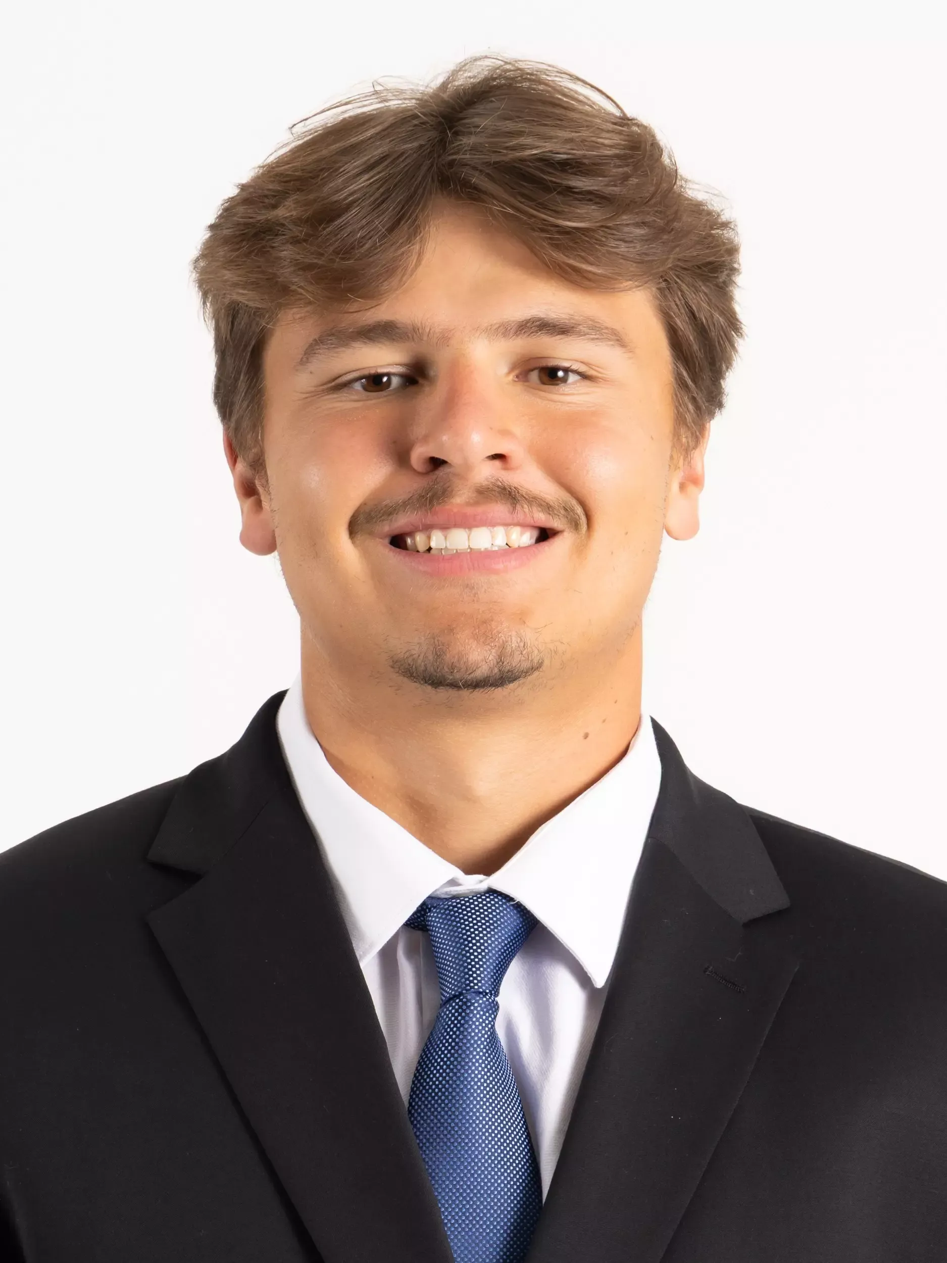 Cole Feinauer headshot in coat and tie