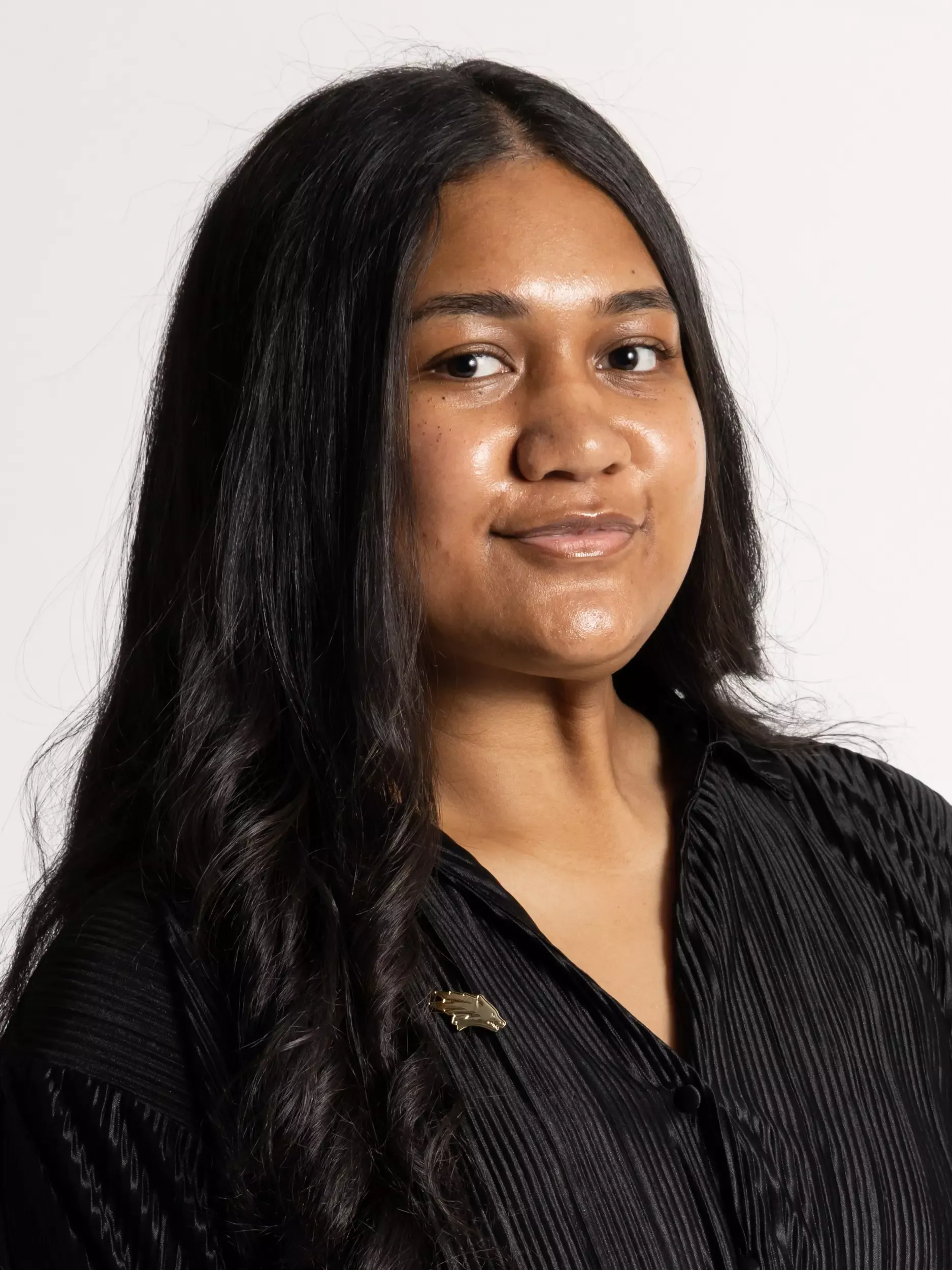 Mele Manu headshot in coat and tie