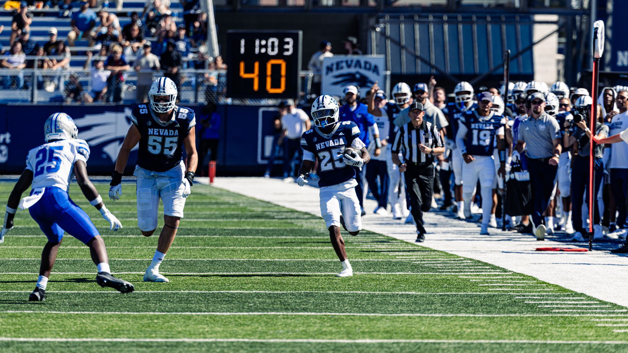 Ky Woods runs down the sidelines with the football