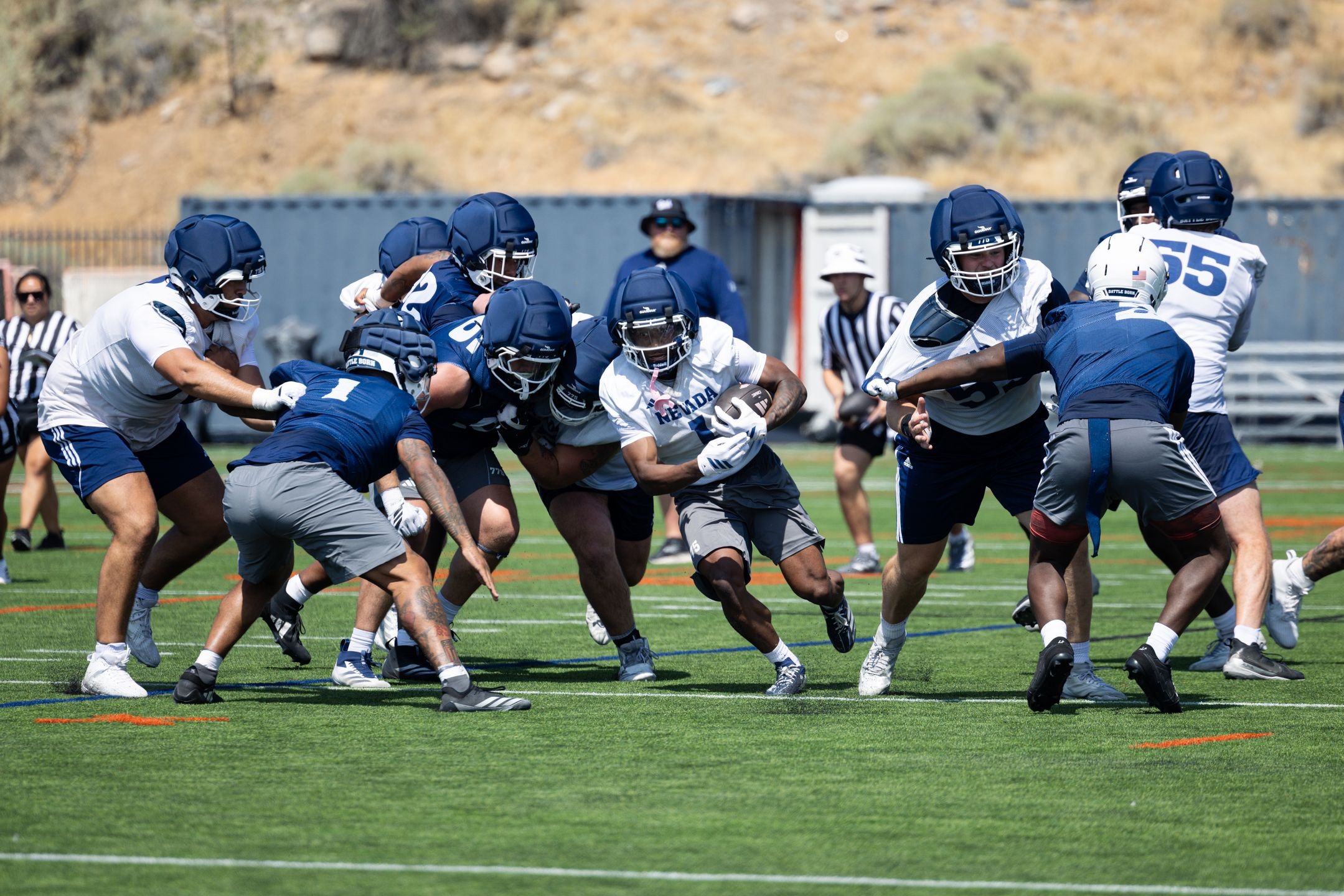 A Nevada football player carries the football through the line of scrimmage