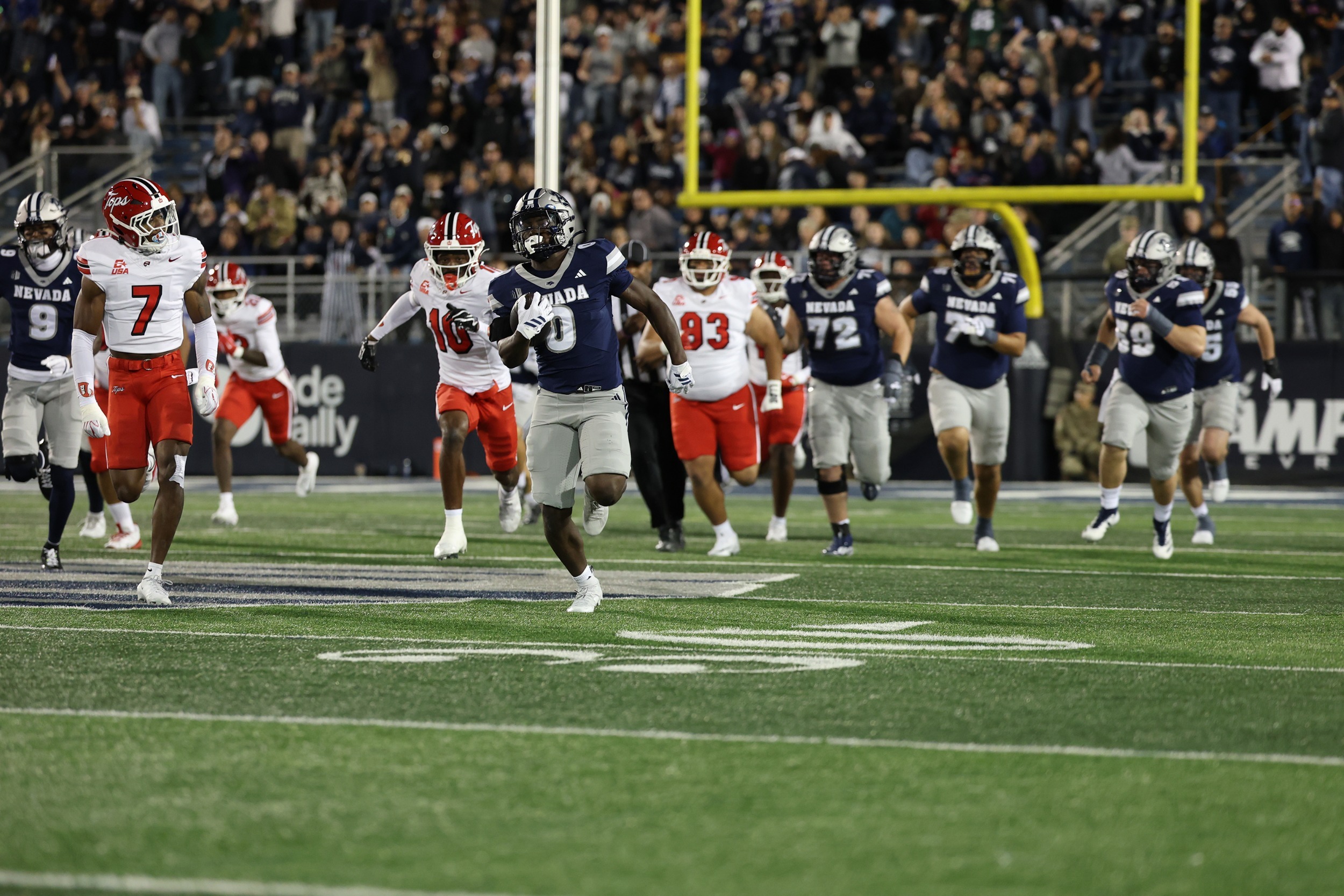 Wolf Pack player running for a touchdown with defenders chasing him