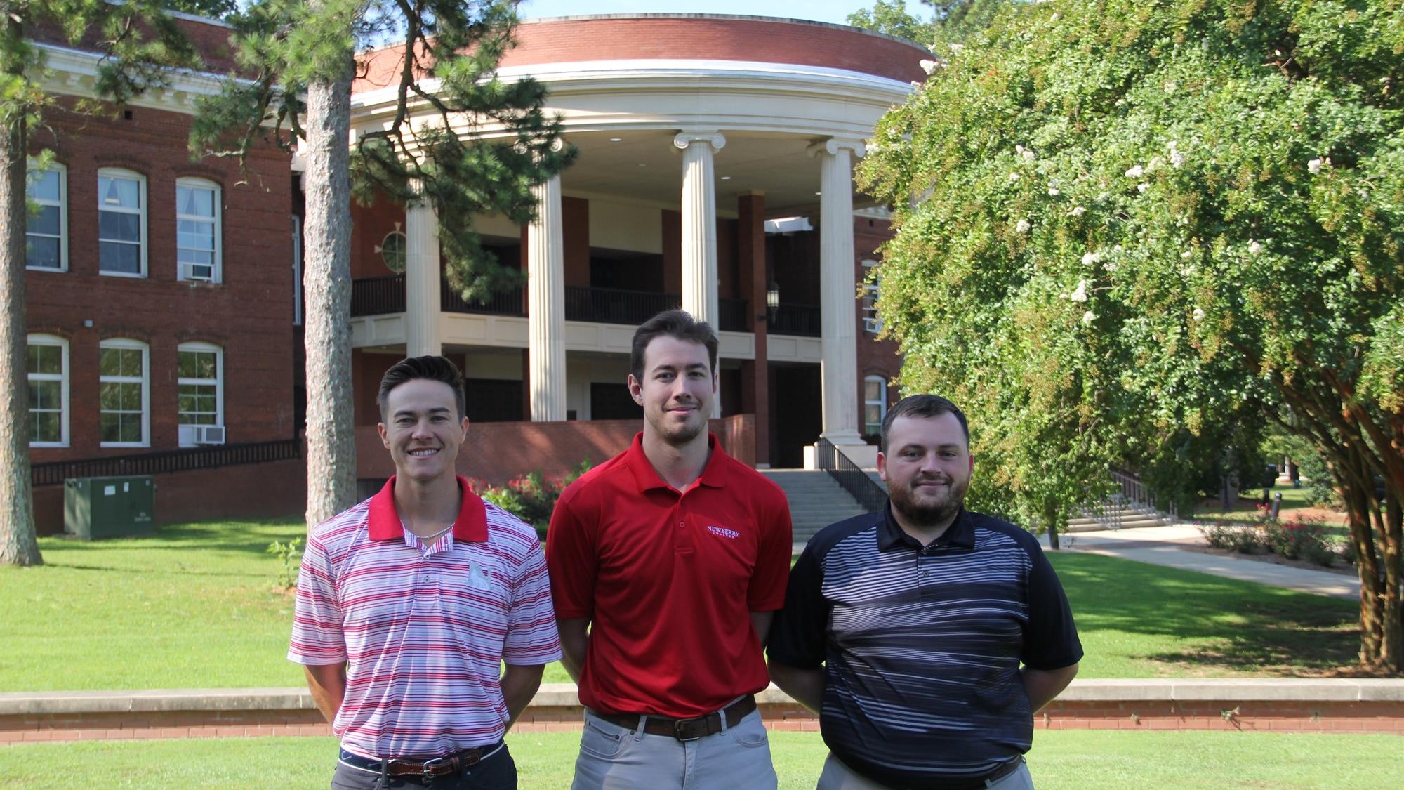 Jordan Szustwal, Preston Elwell, and Michael Spratt stand in front of Holland Hall