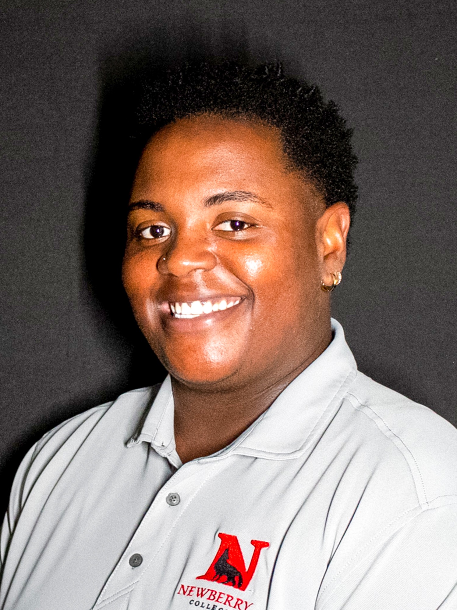 headshot of mashario Morton in a grey polo and black background
