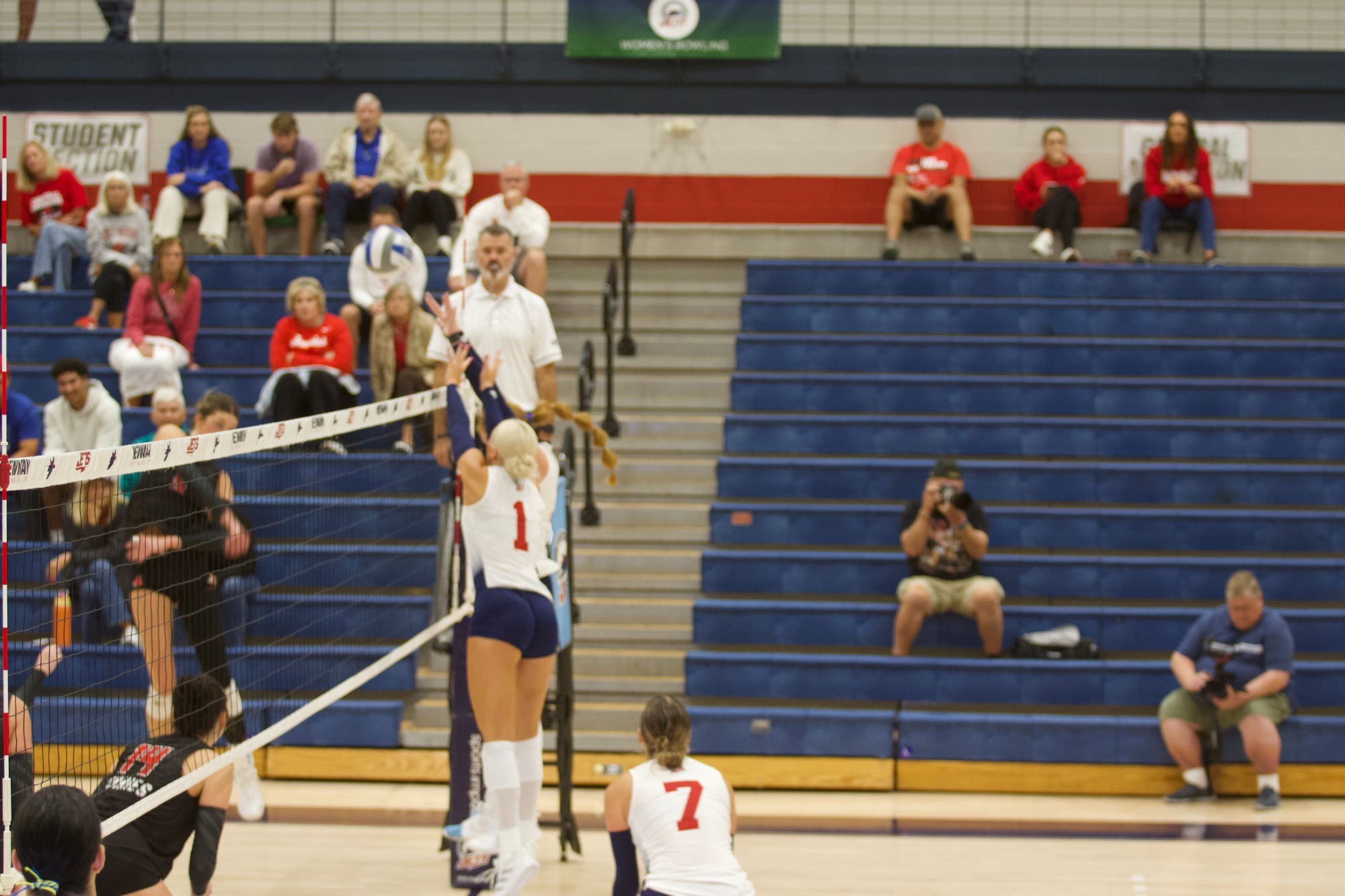 Two Newman players make a block