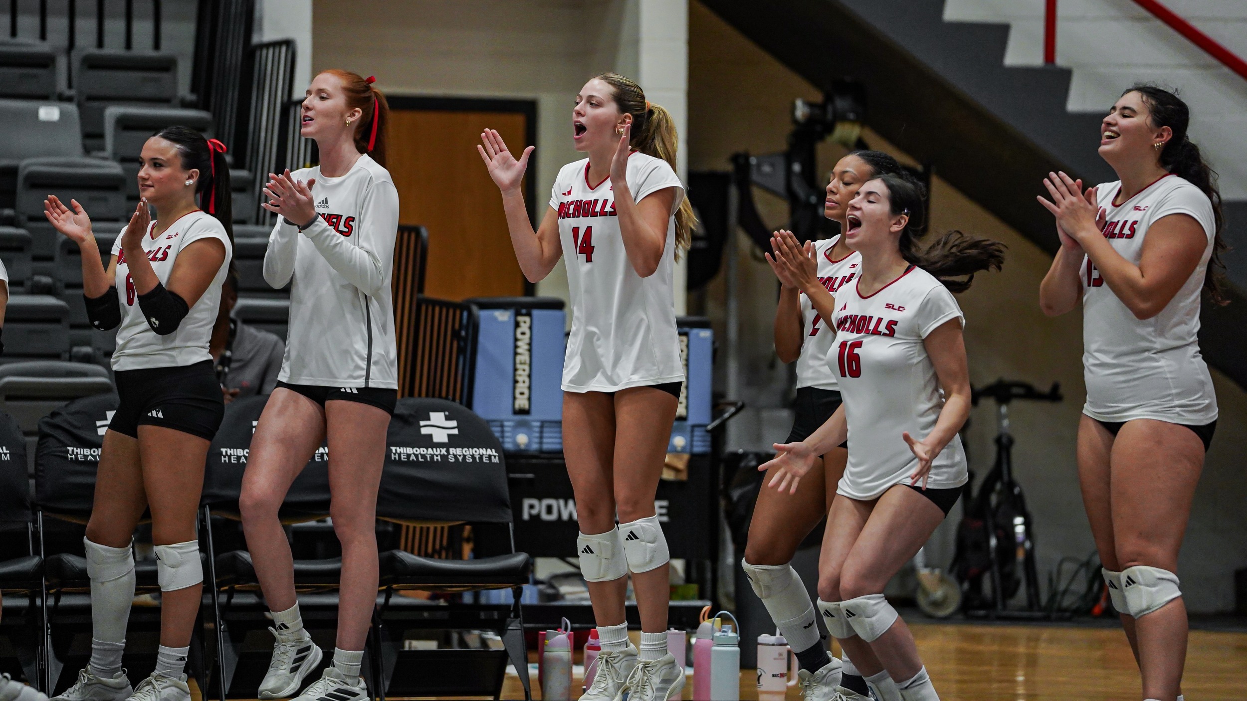 Nicholls Volleyball players on bench celebrating a point 