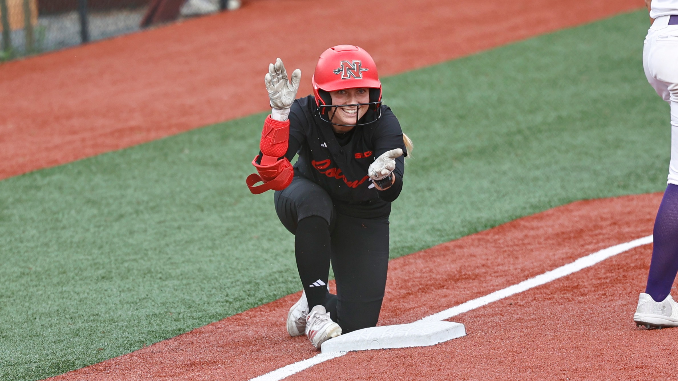 Claire Sisco claps at third base after hitting a triple