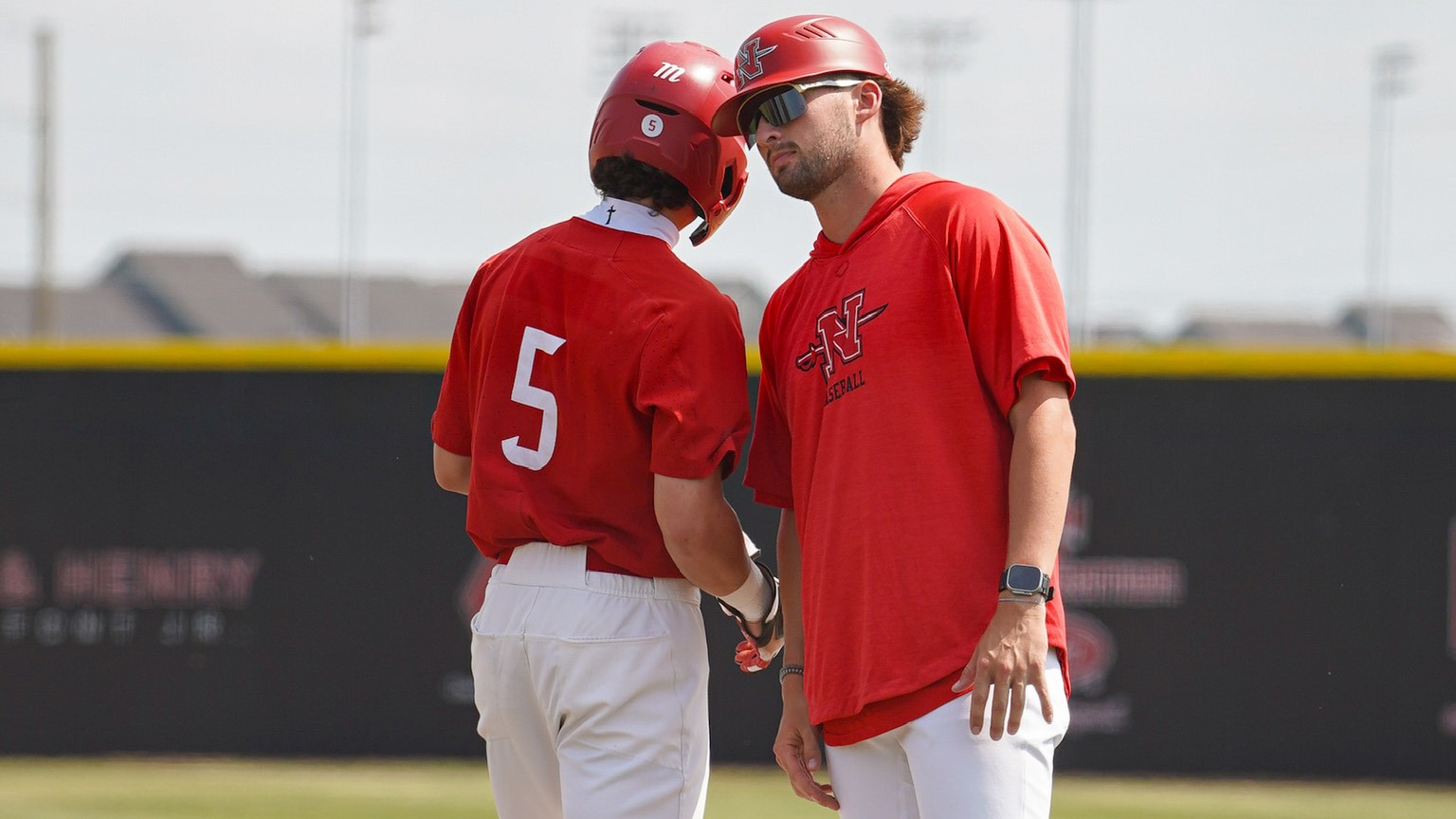 Casey Artigues/Coach Kade Trichel celebrate a base hit at first base