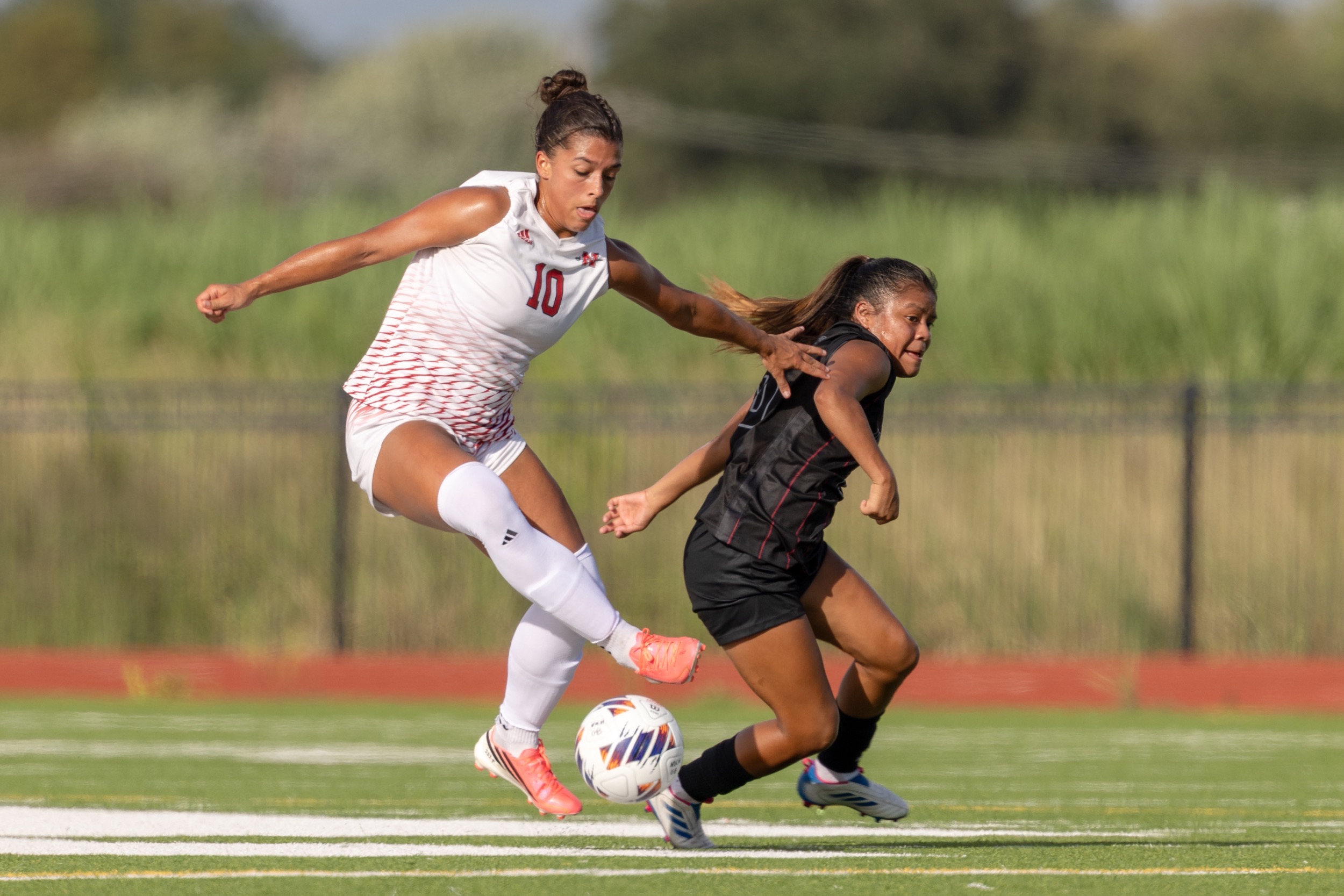 Kate Guillory dribbles past a defender for Nicholls Soccer
