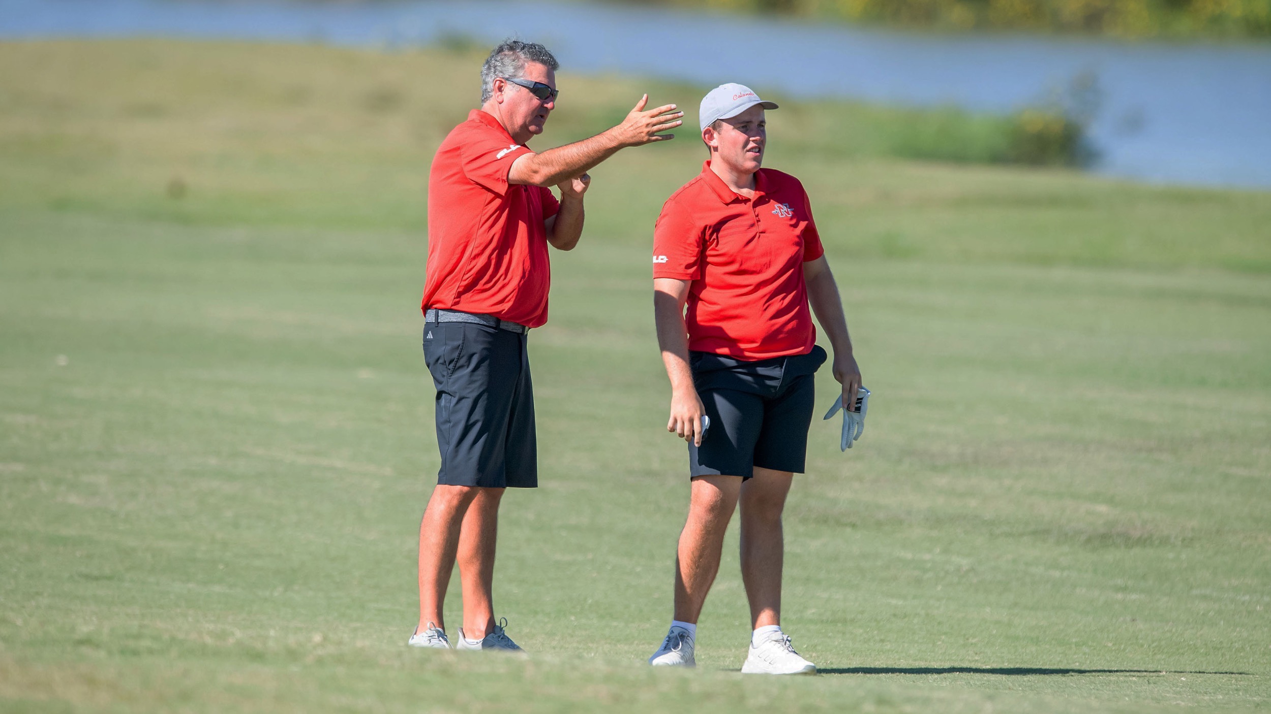 Coach James Schilling talks to Colonel golfer James Bould on the course