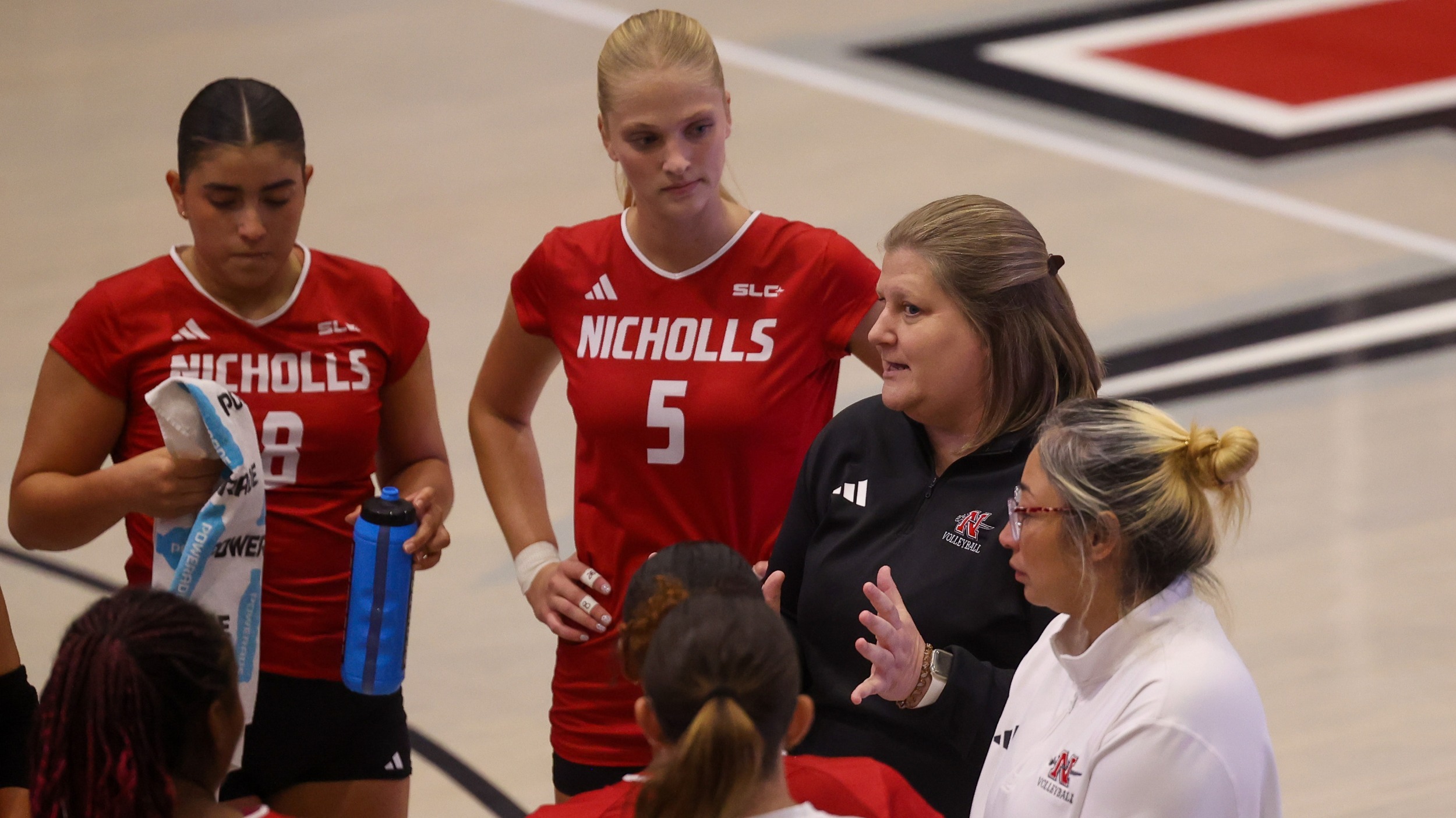 Volleyball coach Jonea Rima talks to team during timeout