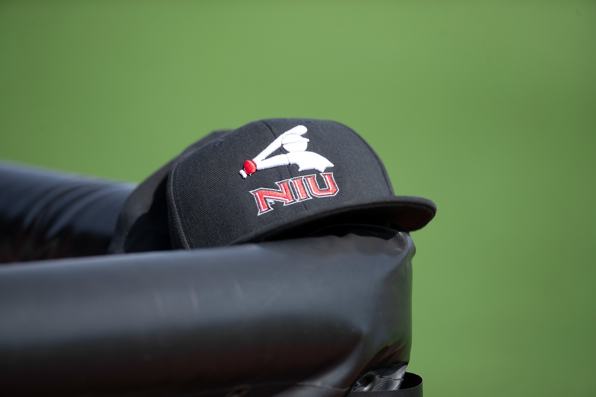 BASE - NIU Baseball Cap on dugout rail