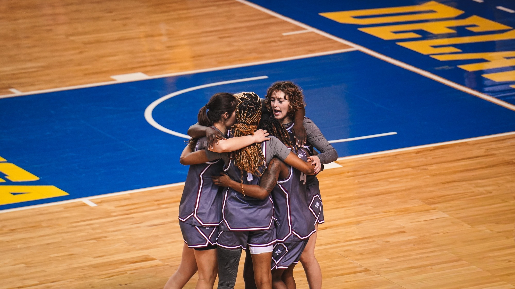 NM State starting lineup having a huddle ahead of the opening tip against Delaware (2/12)