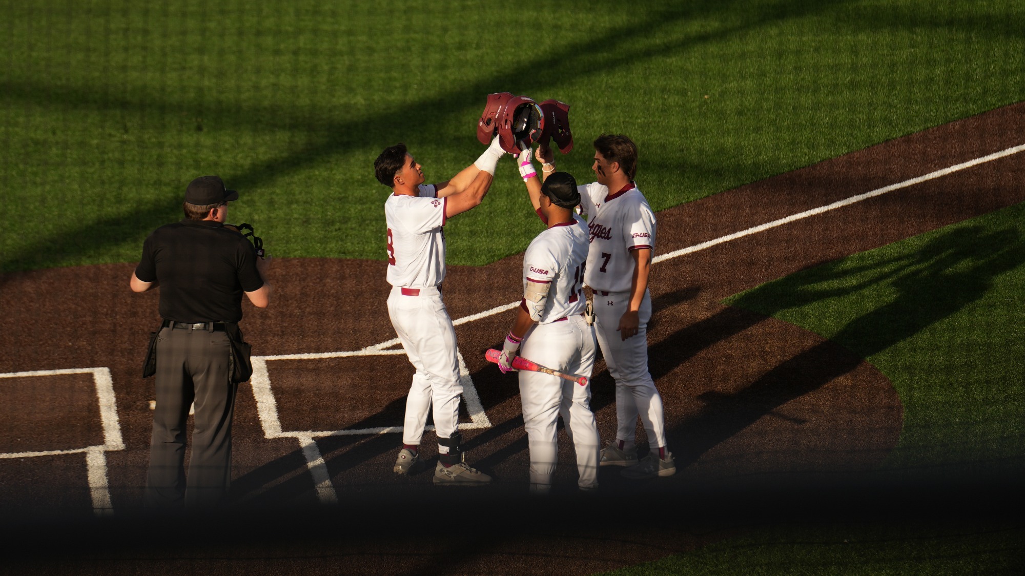 Aidan Taclas, Boston Vest and Steve Solorzano celebrate a home run.