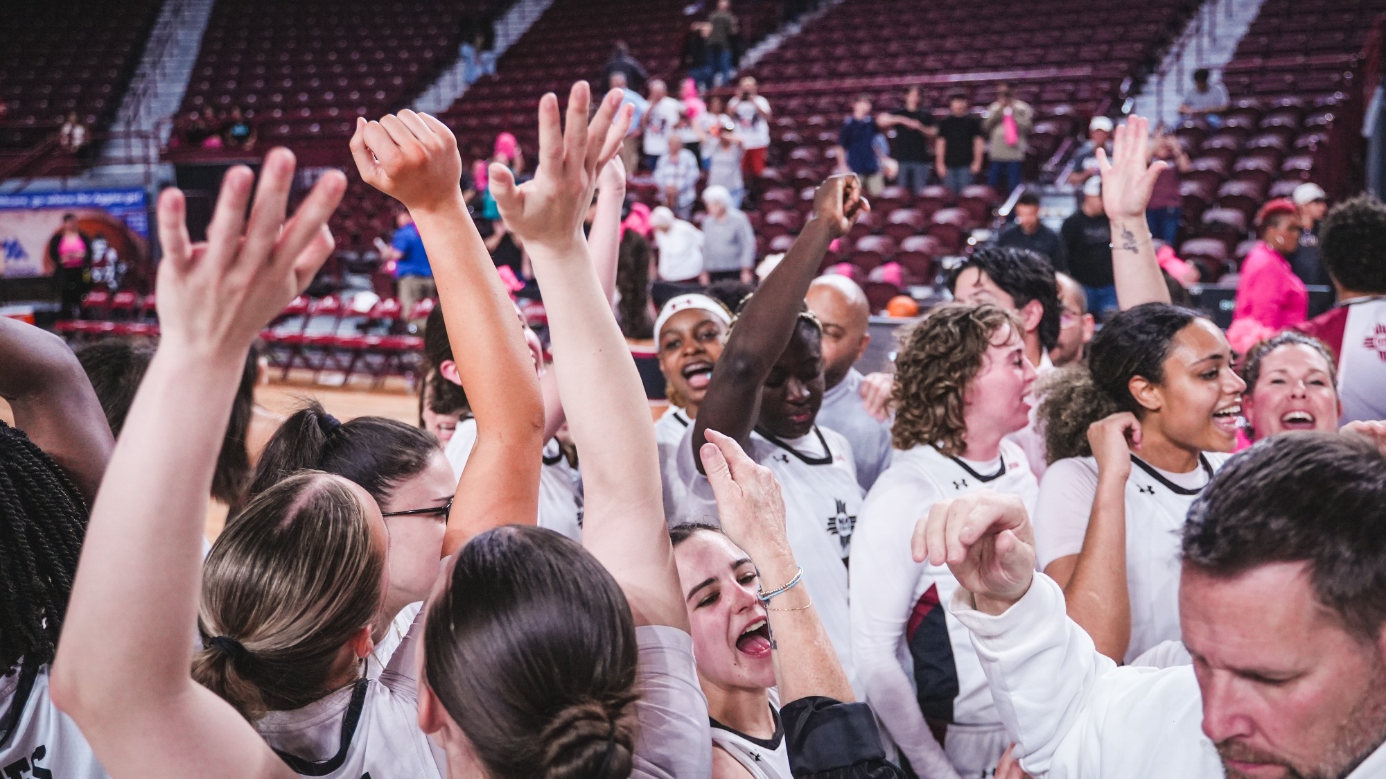 Team celebrating a win in a post-game huddle against KSU (2/26)